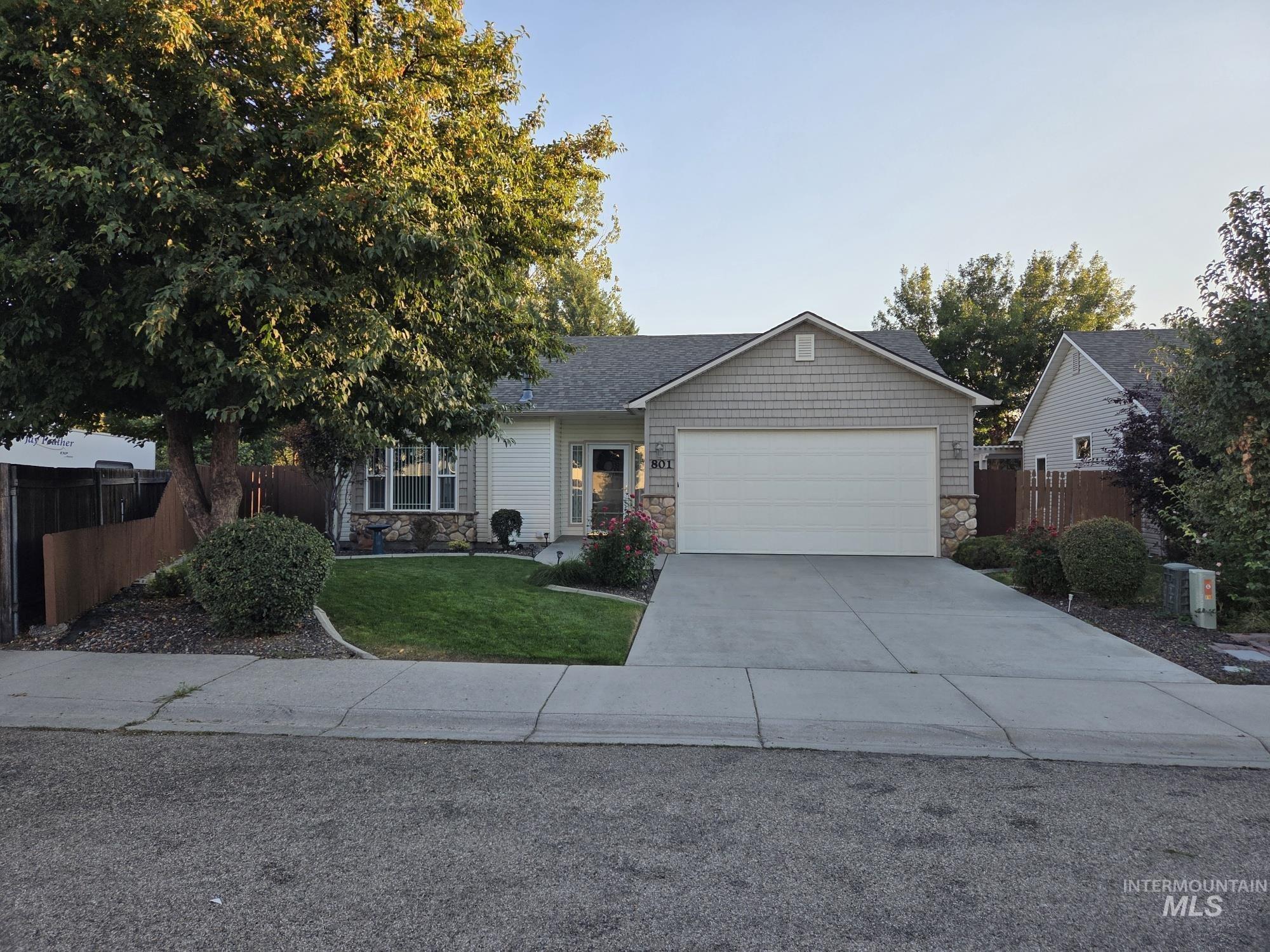 Single story home featuring stone siding, concrete driveway, and an attached garage