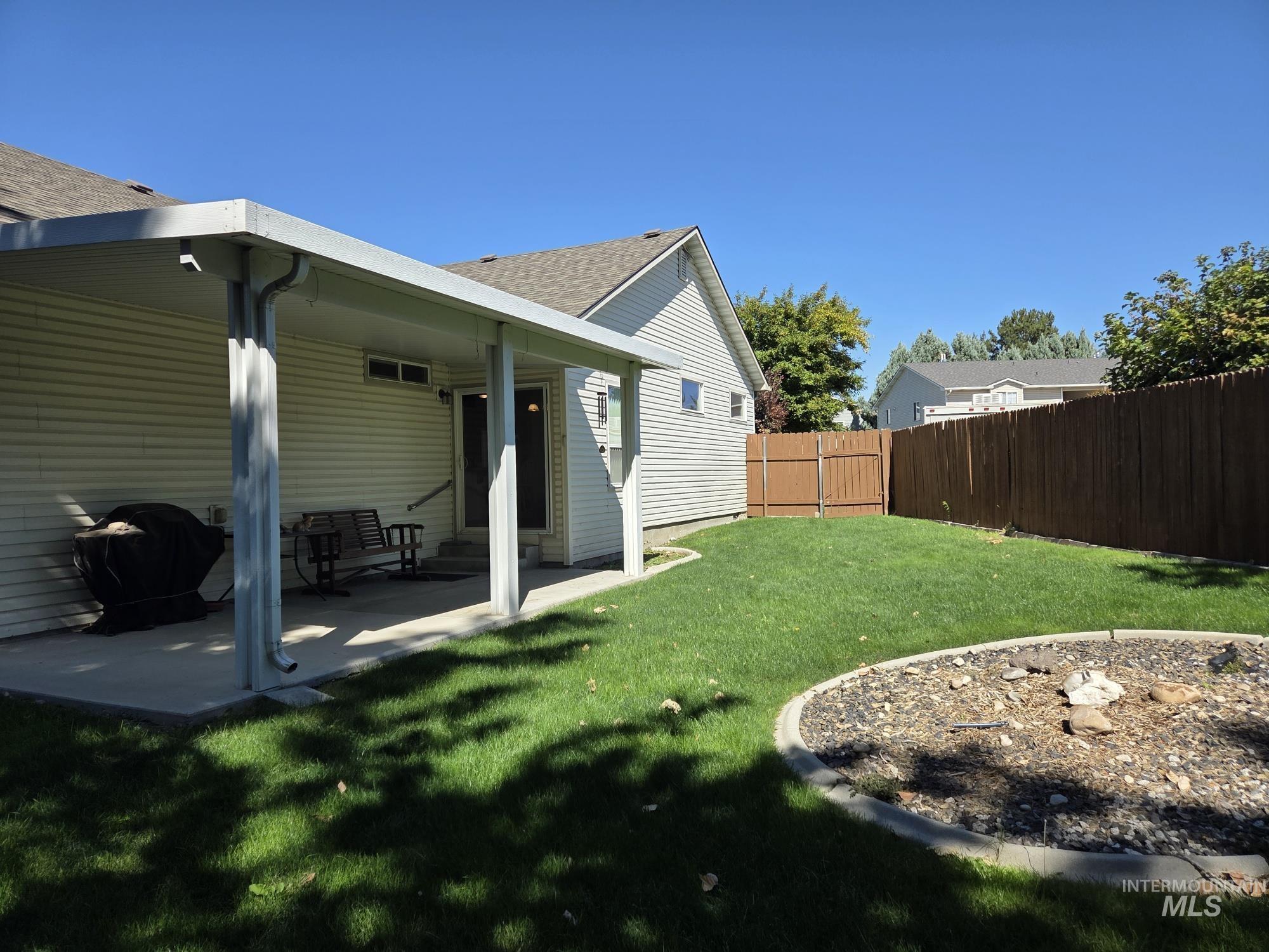 Rear view of property with a patio area, a fenced backyard, and roof with shingles