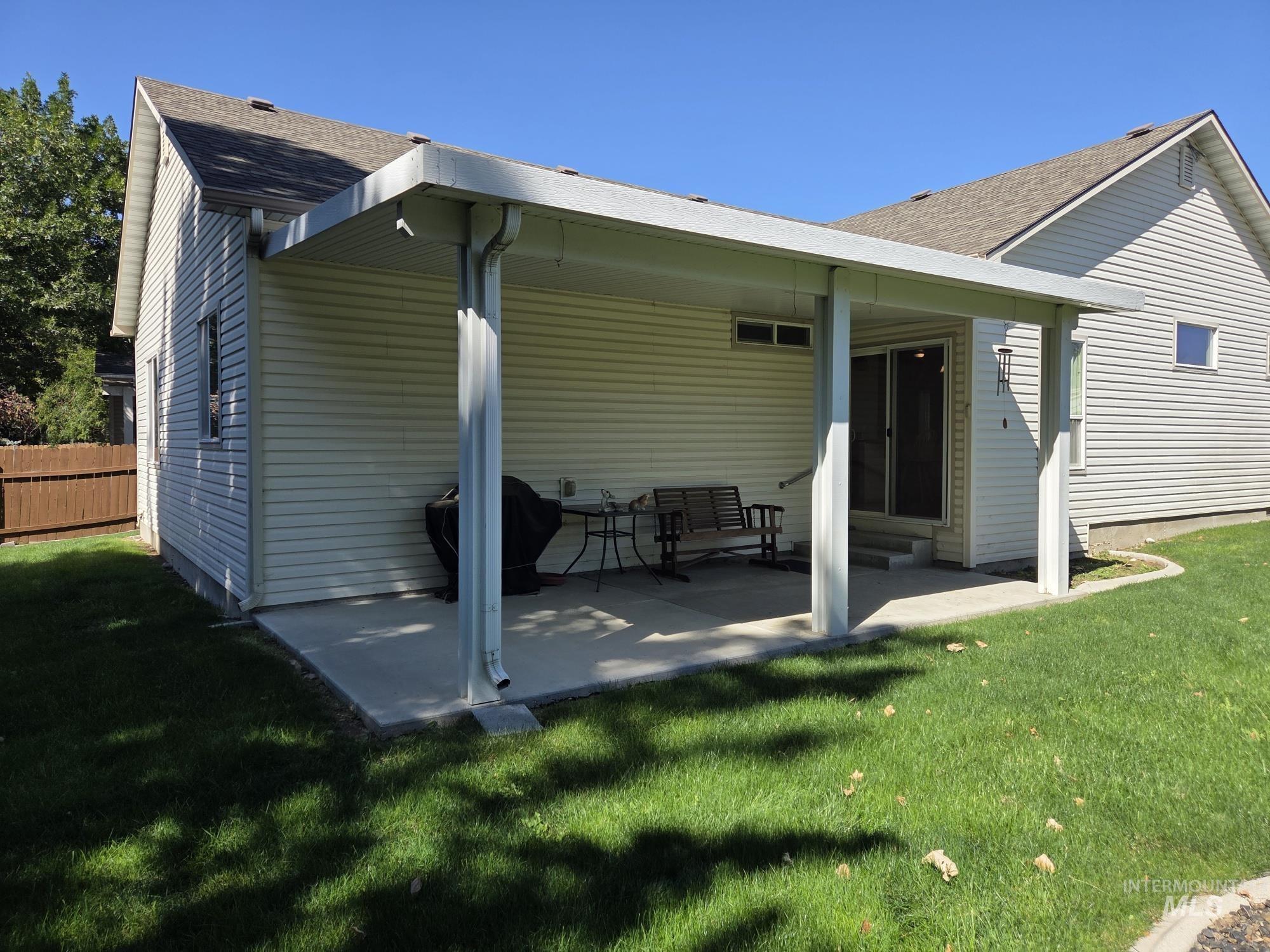 Back of property with a patio area and a shingled roof