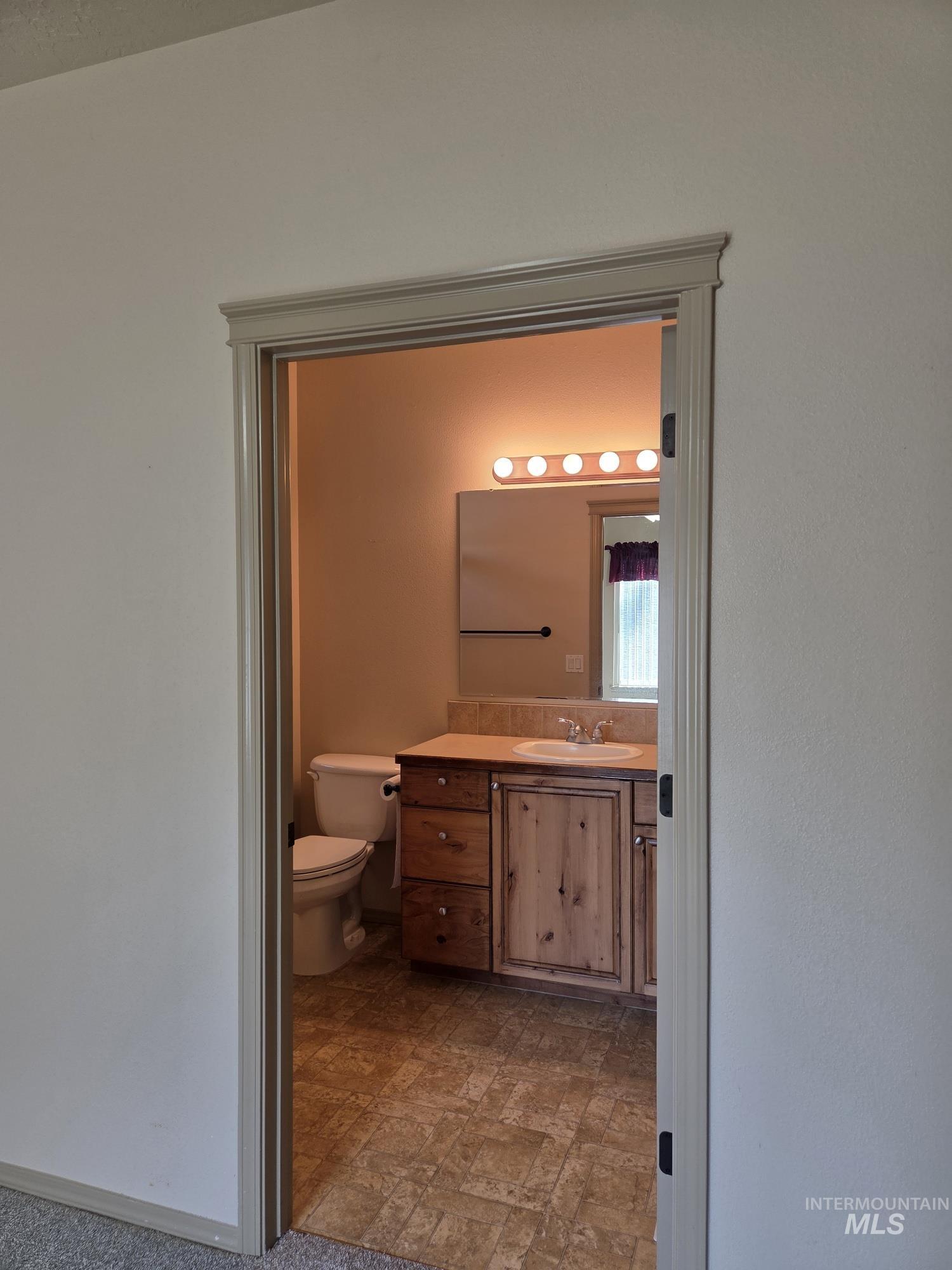 Half bathroom with vanity and stone finish floors