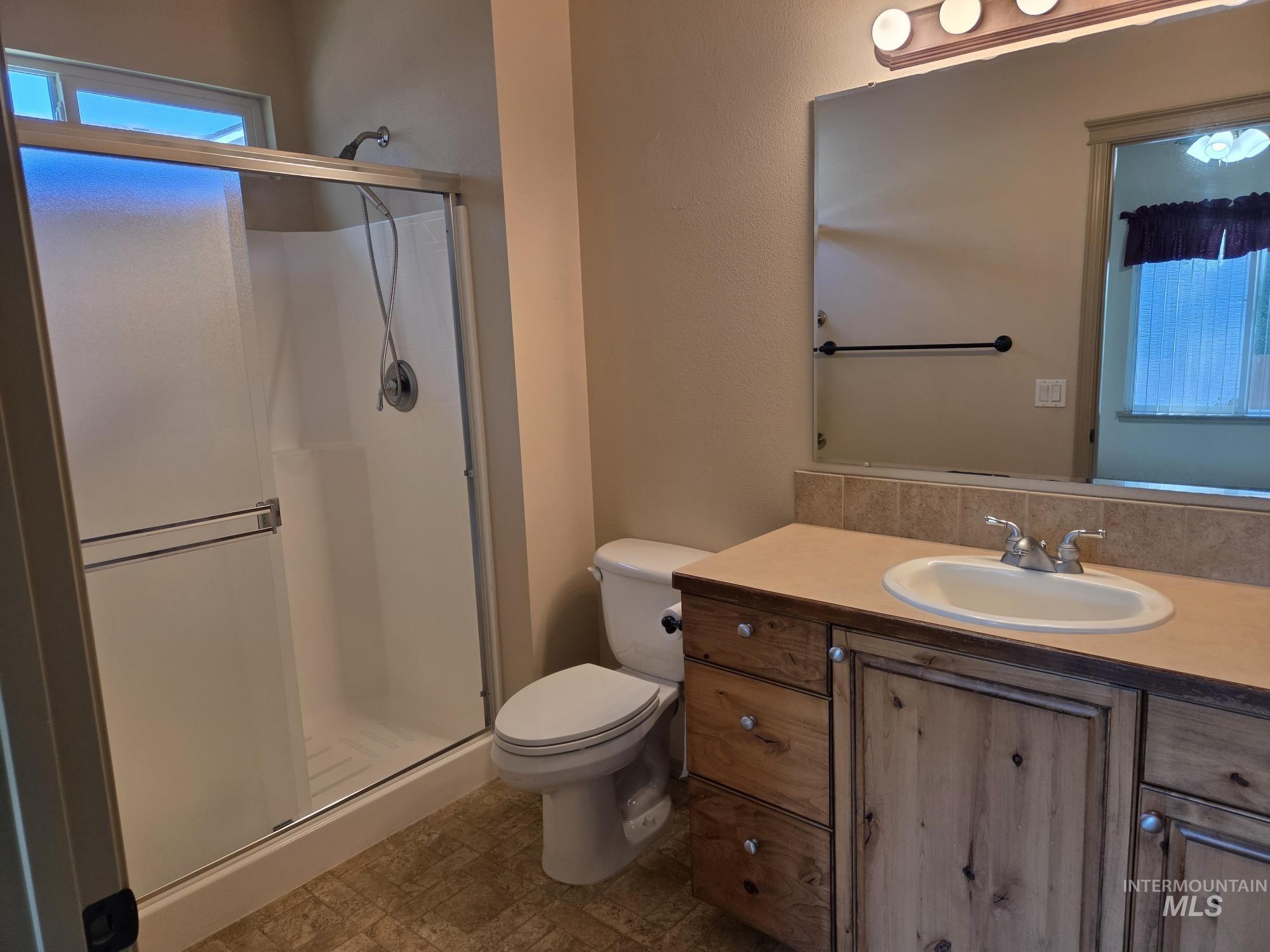 Bathroom featuring vanity and a stall shower