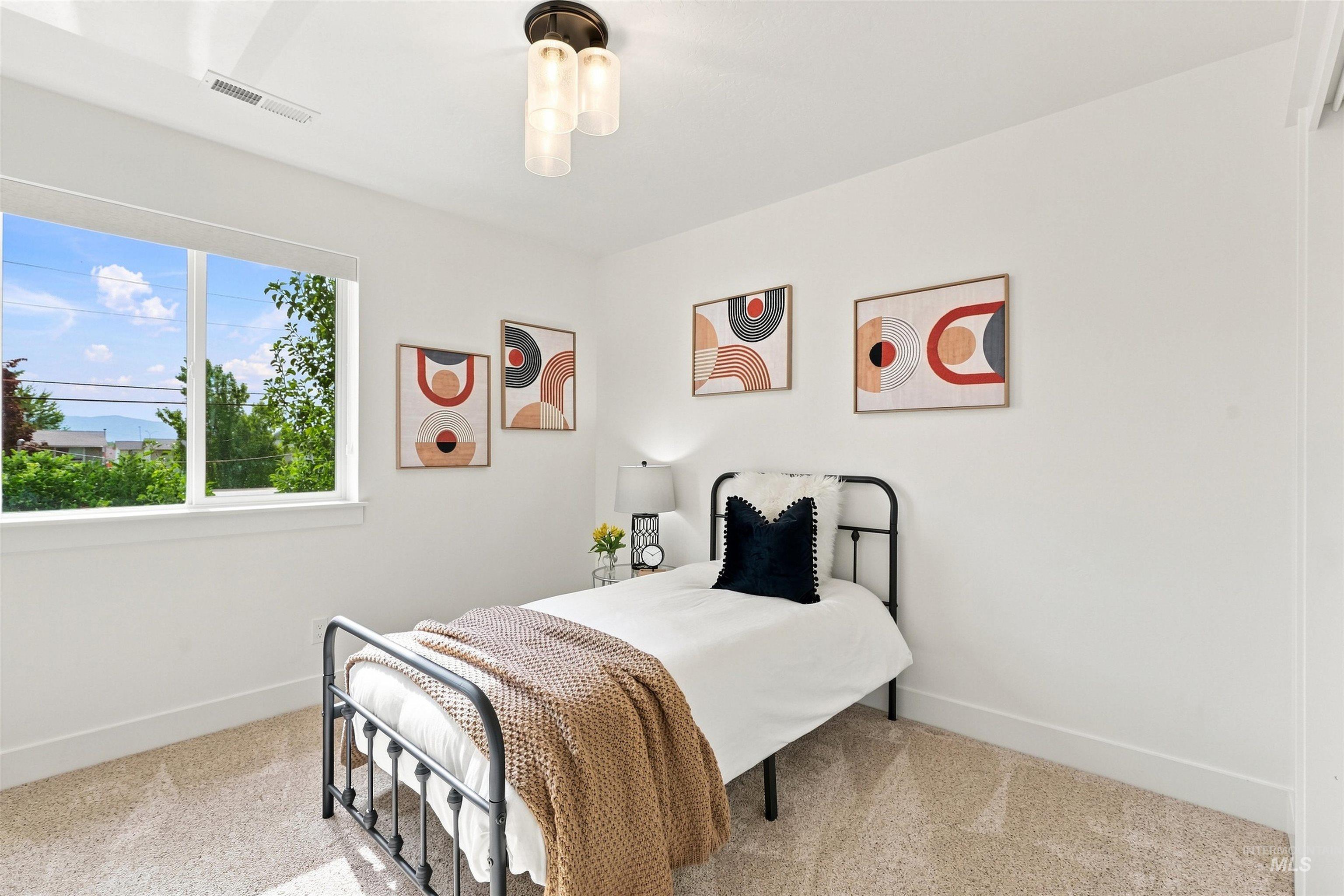 Bright room featuring white walls and neutral-toned carpet flooring