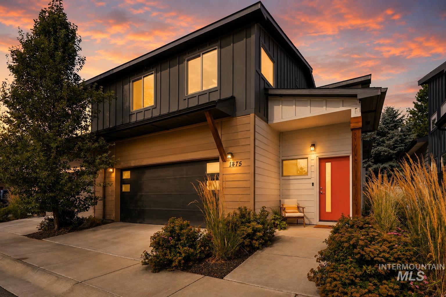 Contemporary two-story exterior with mixed material siding, featuring vertical dark paneling and horizontal light-toned siding