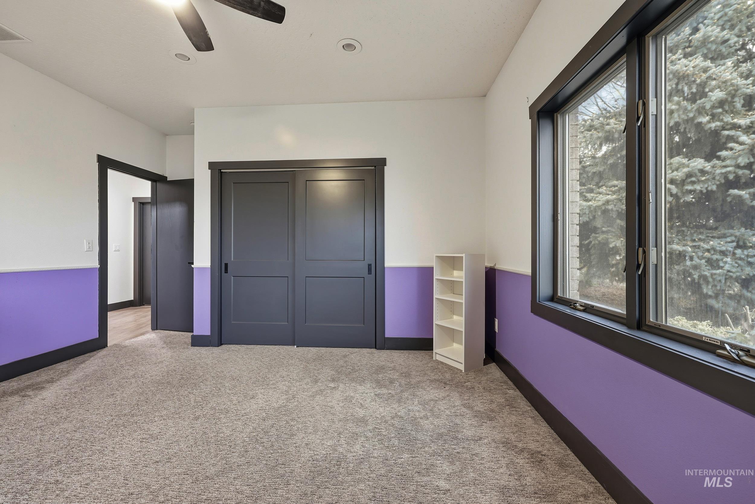 Unfurnished bedroom with a closet, carpet flooring, and a ceiling fan