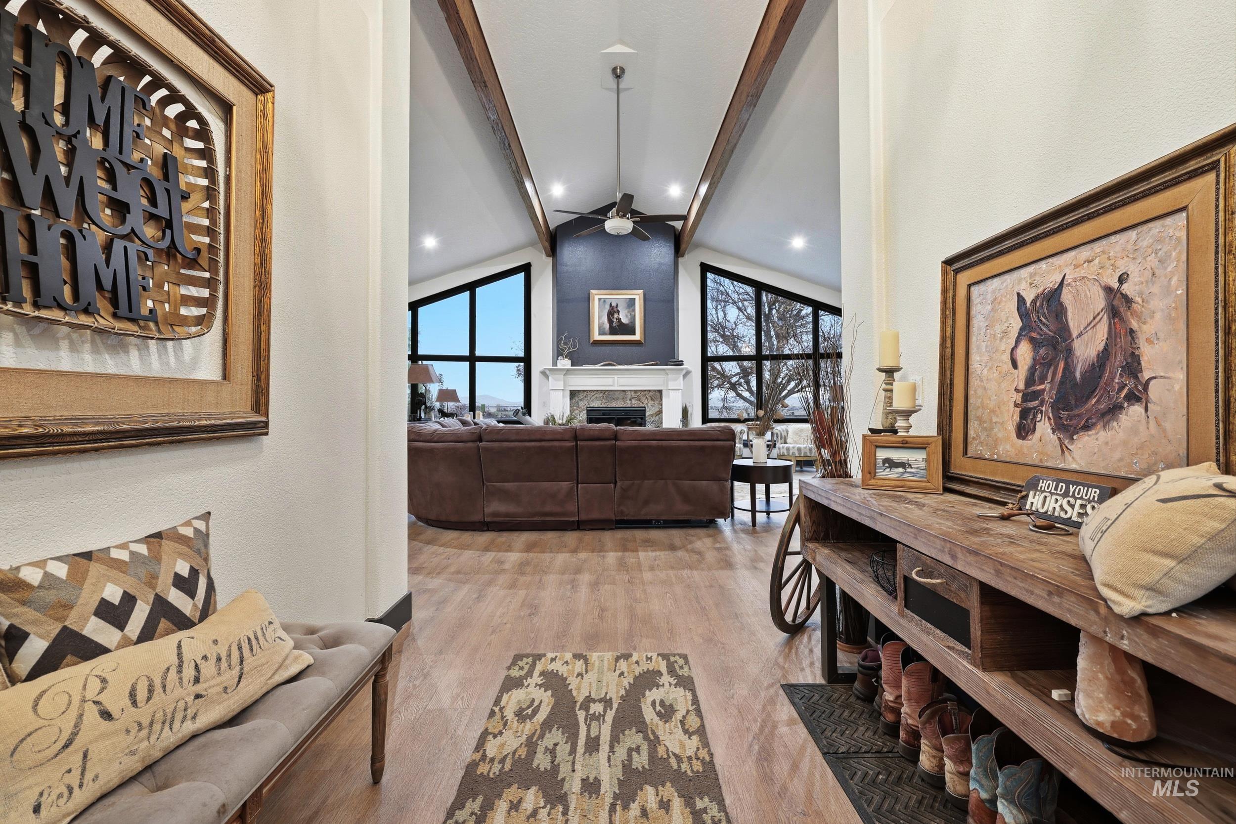 Hallway with light wood-type flooring, beamed ceiling, and high vaulted ceiling