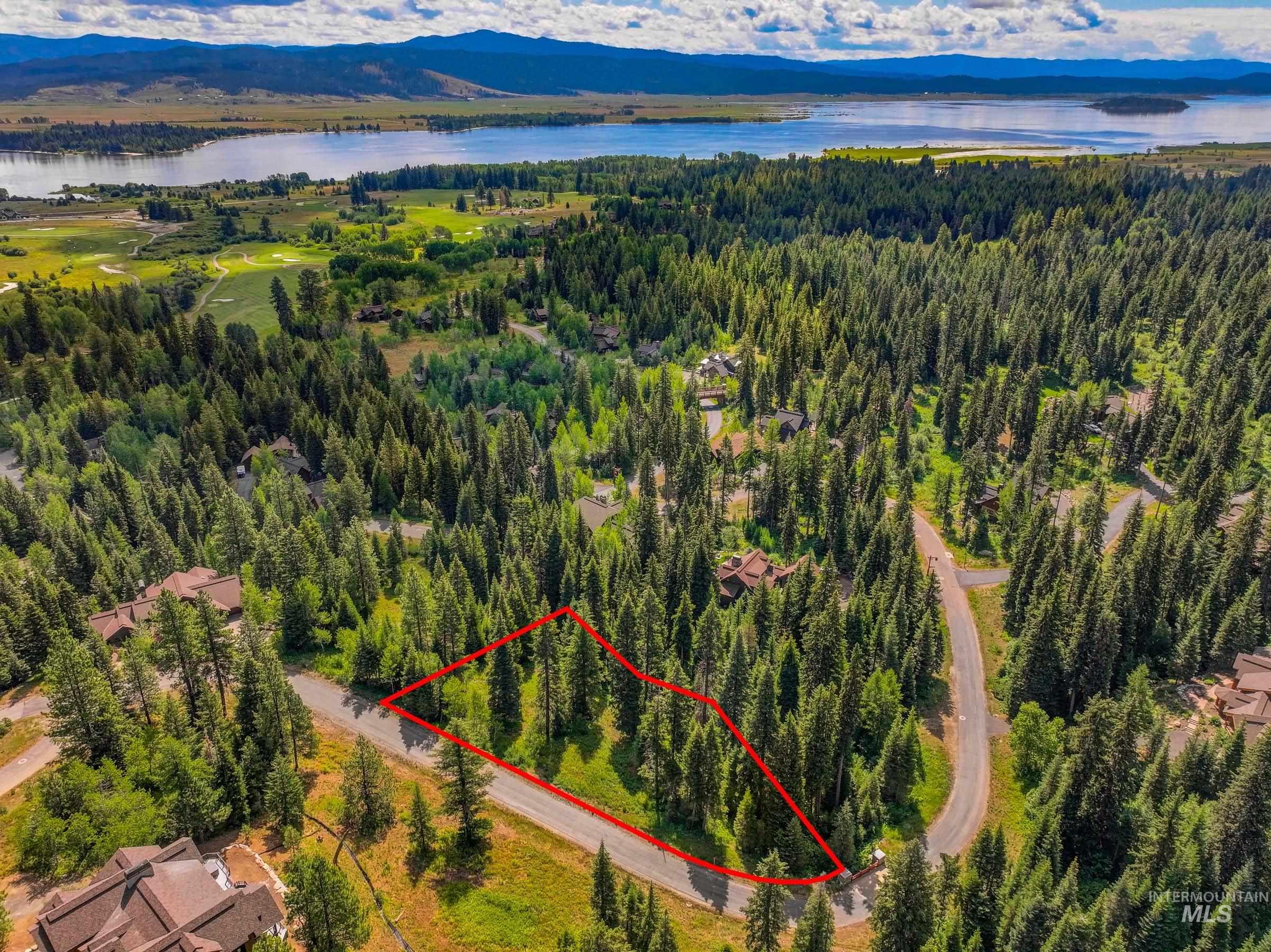 Aerial view of property and surrounding area with property parcel outlined and a nearby body of water