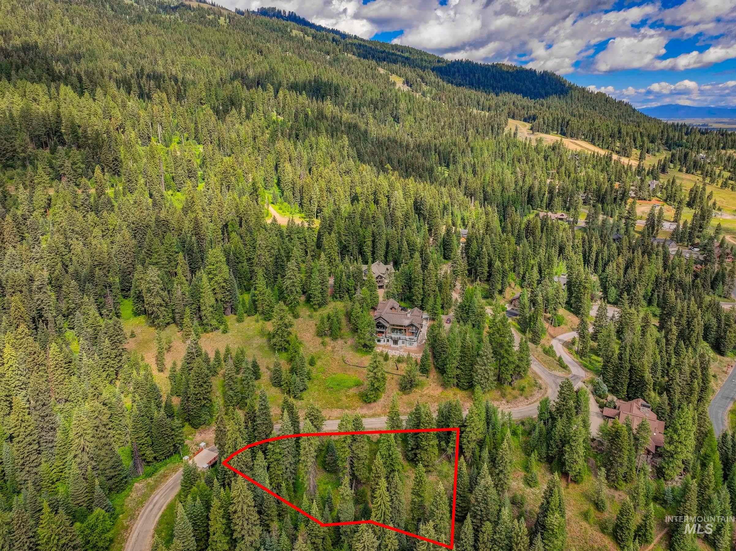 Aerial view of property's location with property boundaries highlighted and a mountain backdrop
