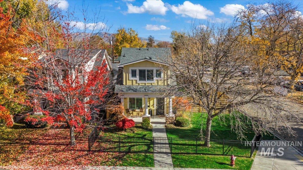 View of front of home featuring a porch, a fenced front yard, stone