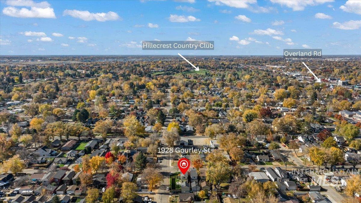 Aerial view of property and surrounding area featuring nearby suburban area