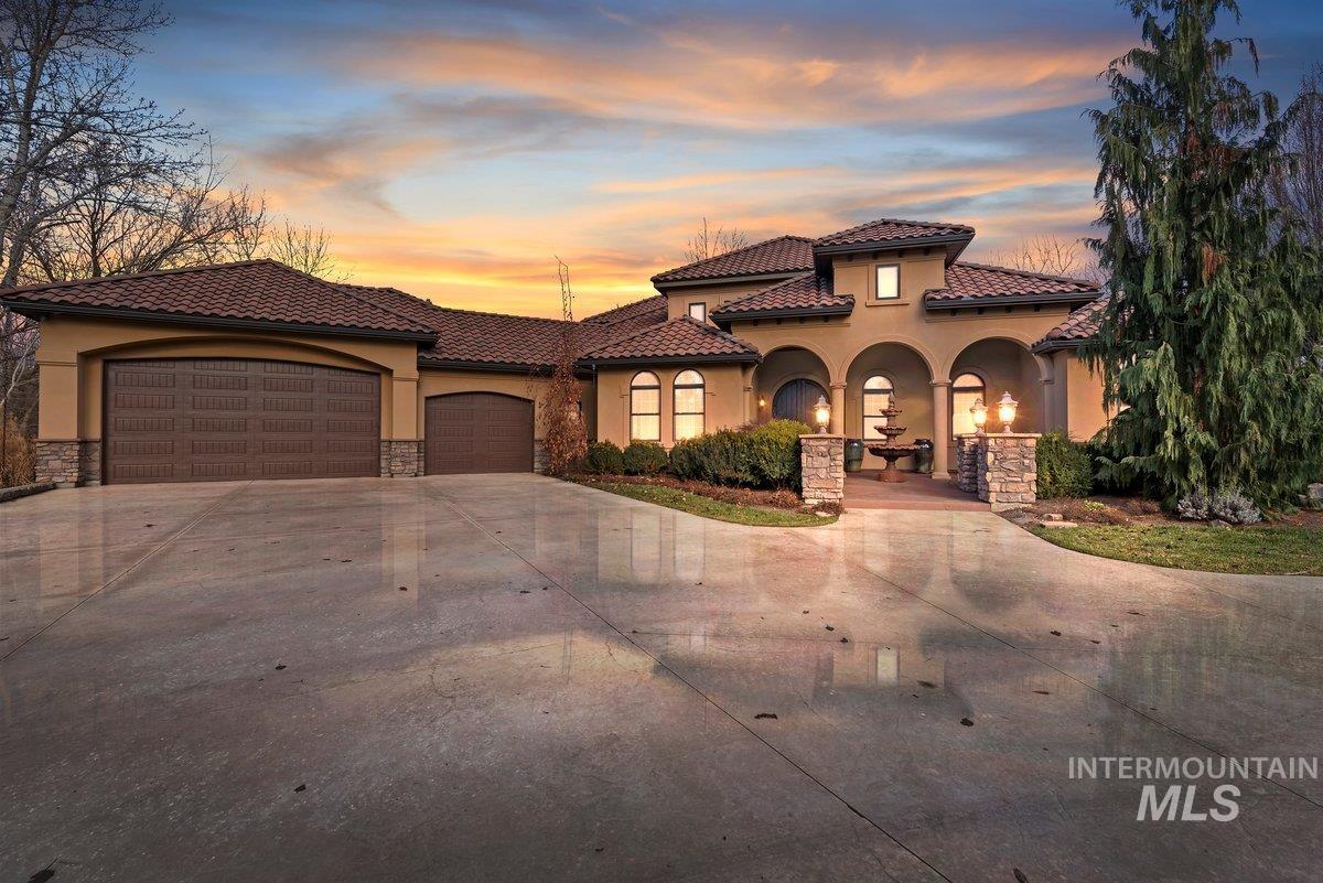 Mediterranean / spanish-style home with stone siding, concrete driveway, stucco siding, and a garage