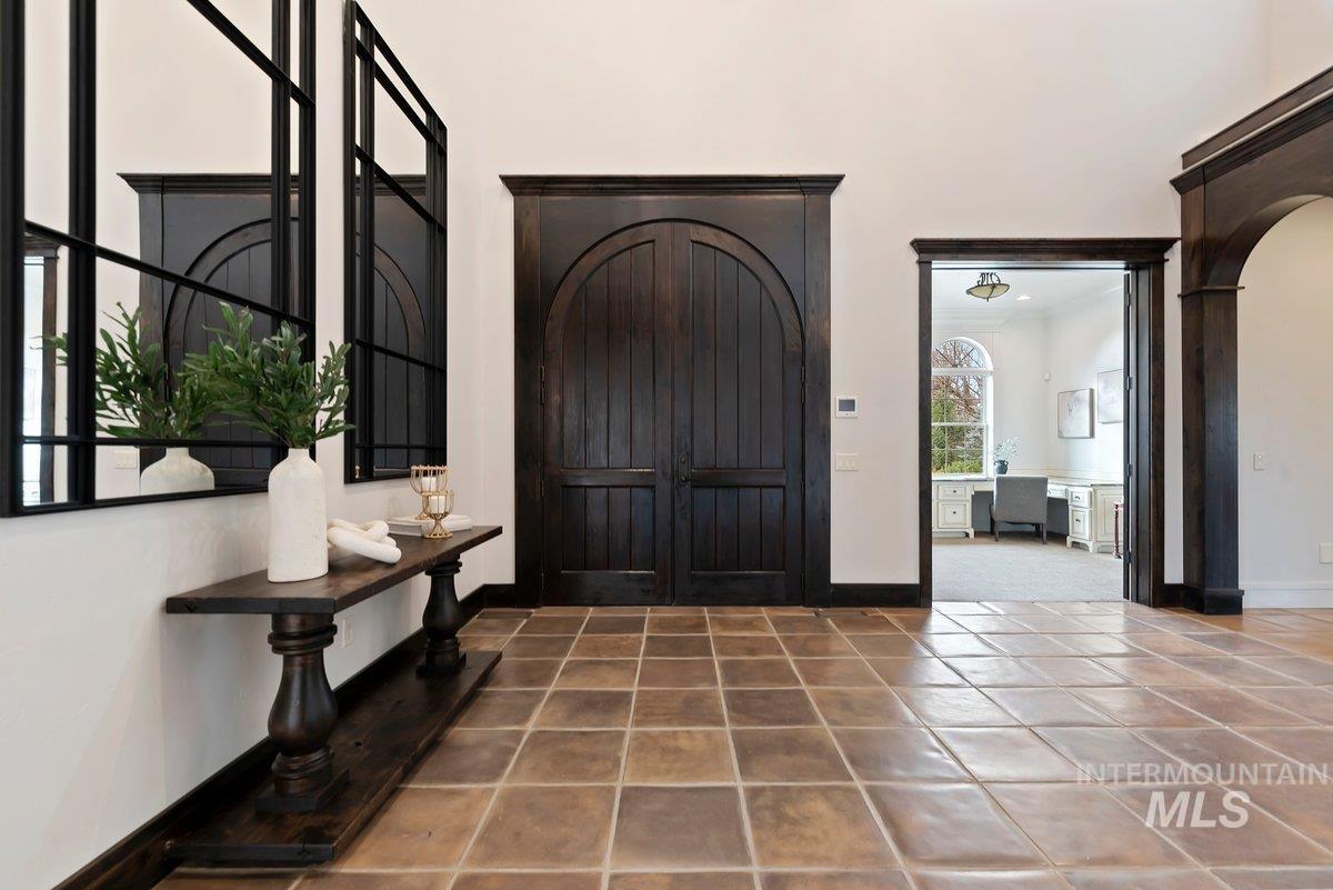 Entryway with arched walkways and tile patterned flooring