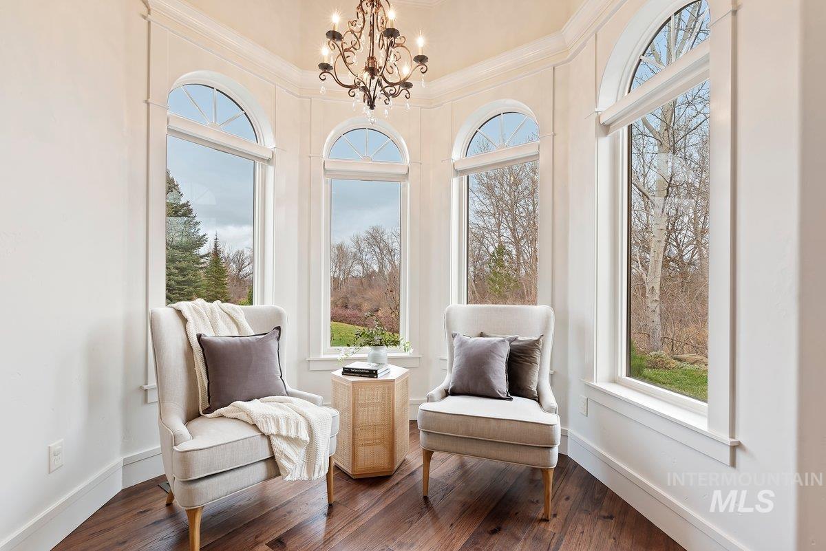 Sunroom / solarium featuring a chandelier, wood-type flooring, and ornamental molding