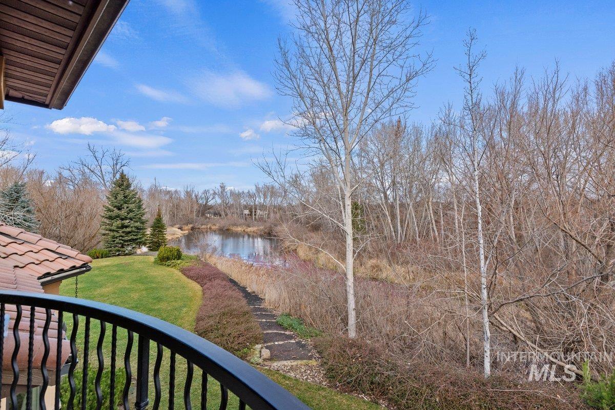 View of green lawn featuring a water view and a balcony