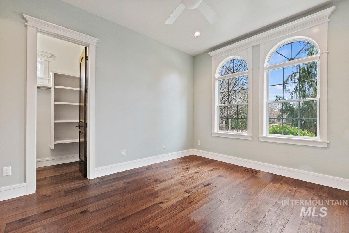 Empty room with dark wood-style flooring and baseboards