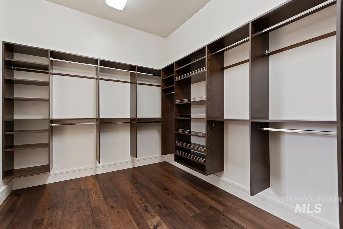 Spacious closet with dark wood-style floors
