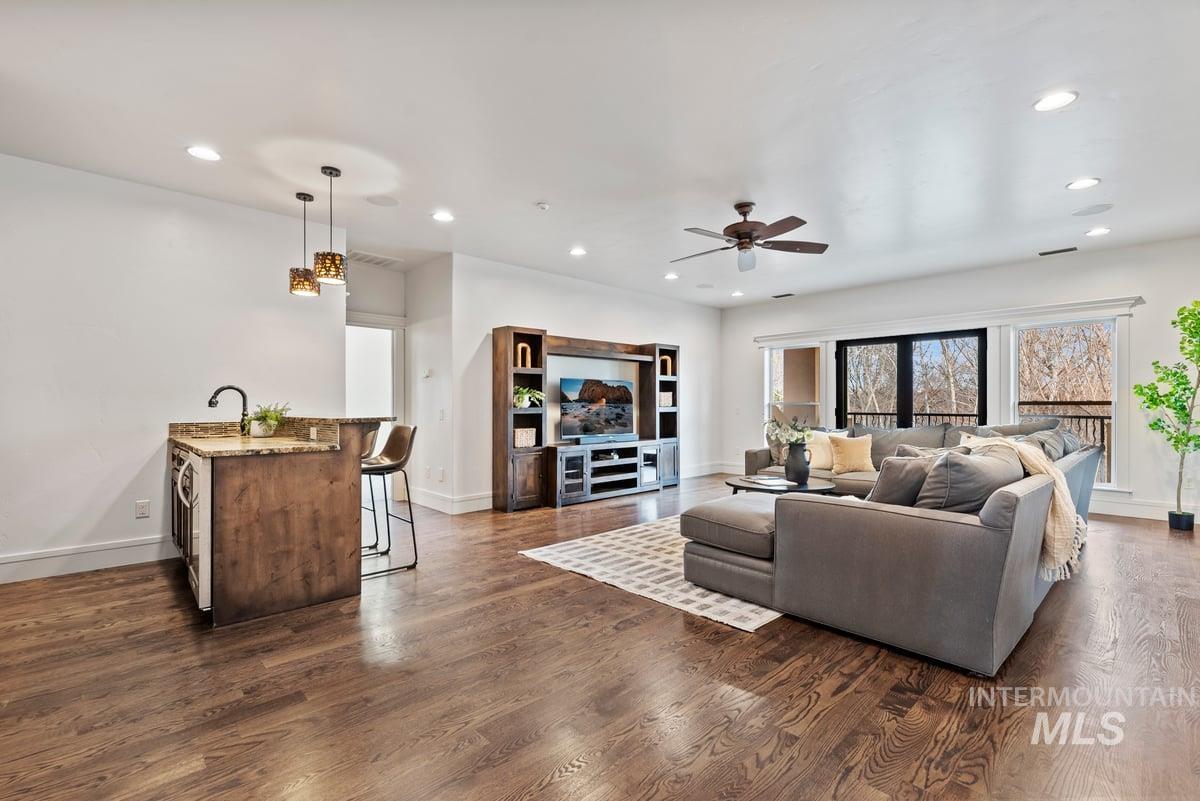 Living room with recessed lighting, dark wood-type flooring, and ceiling fan