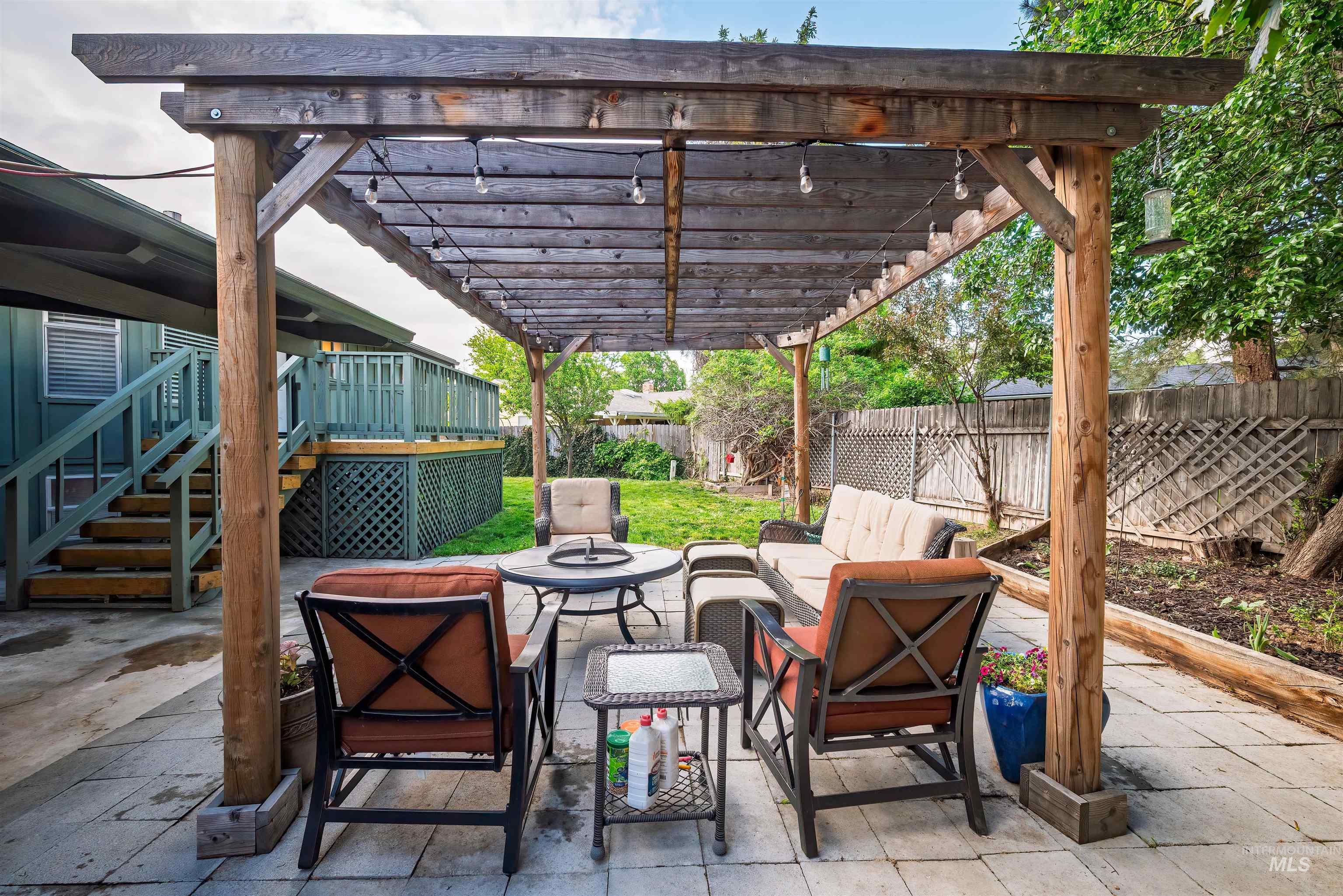 Fenced backyard featuring a patio area, an outdoor living space, a pergola, a deck, and stairway