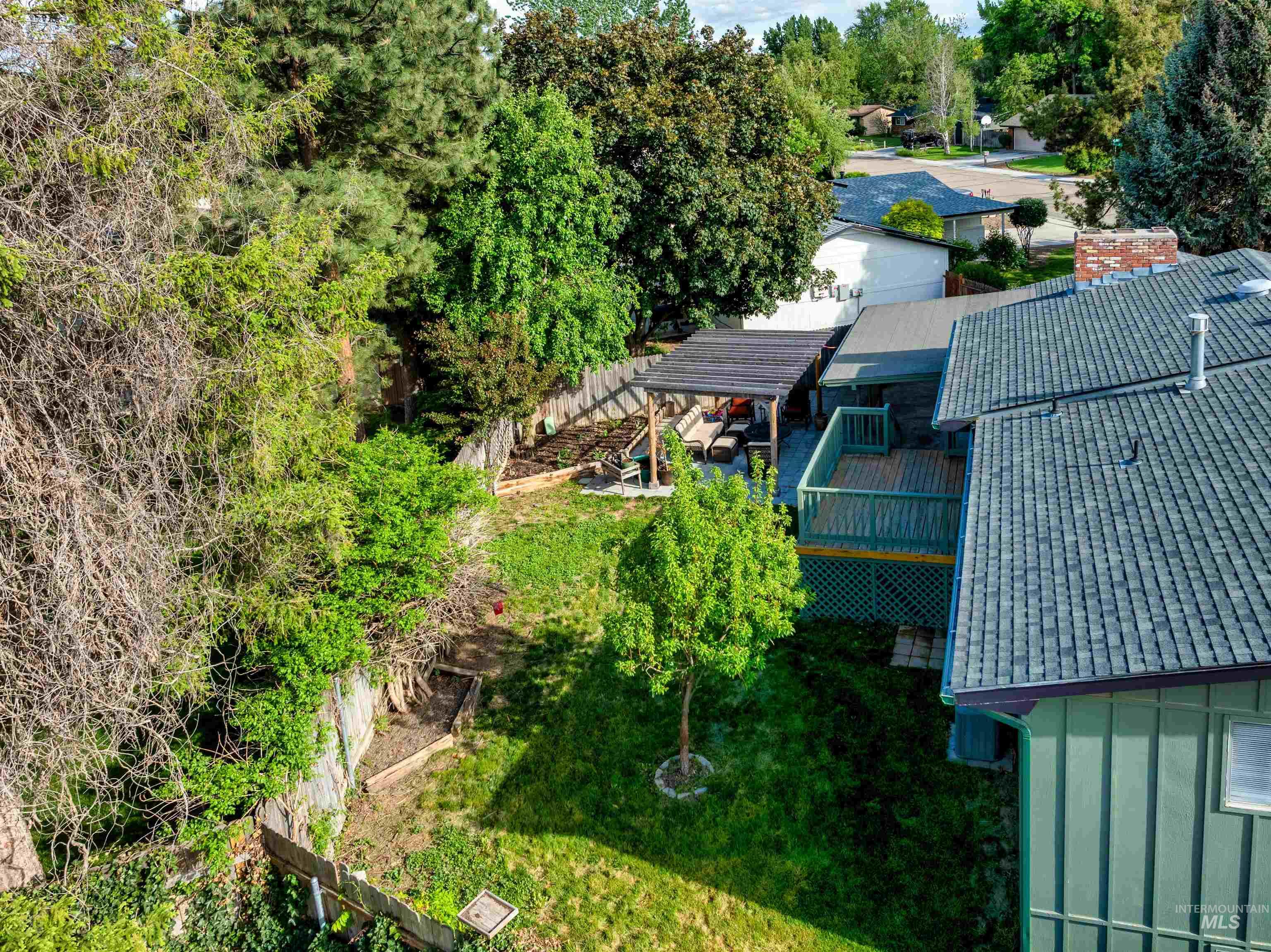 View of subject property featuring a tree filled landscape