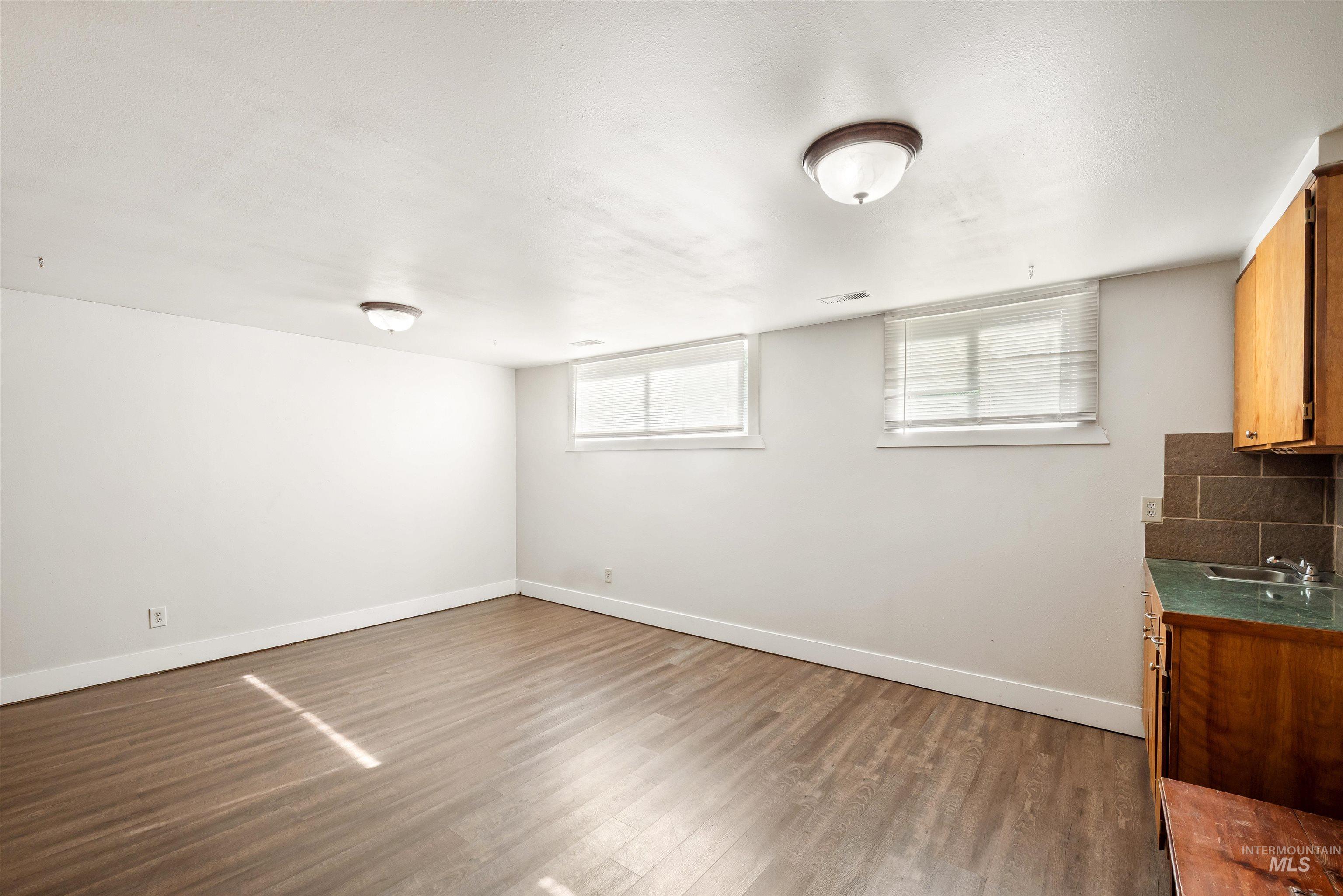 Basement with baseboards and dark wood finished floors