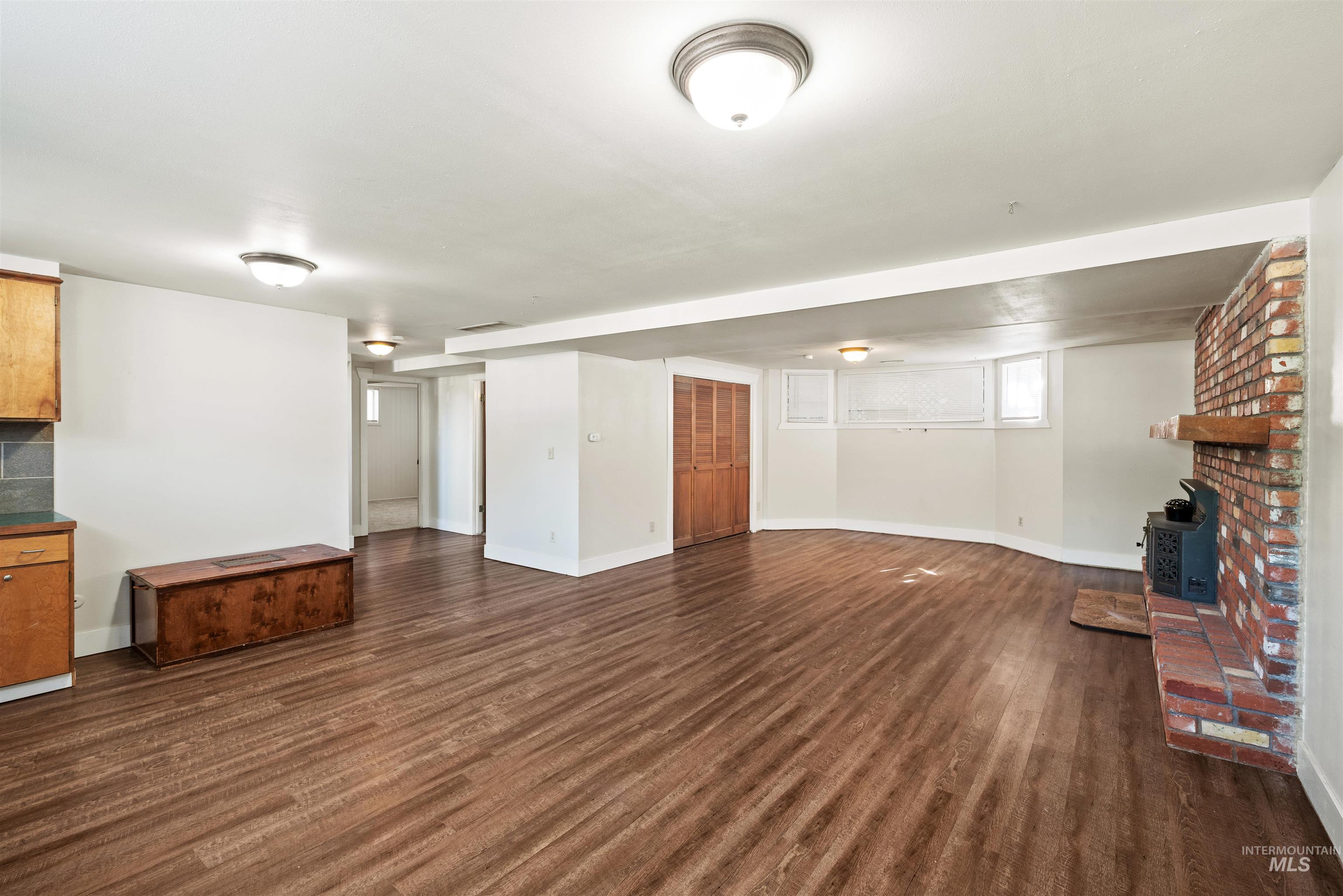 Unfurnished living room with dark wood-type flooring