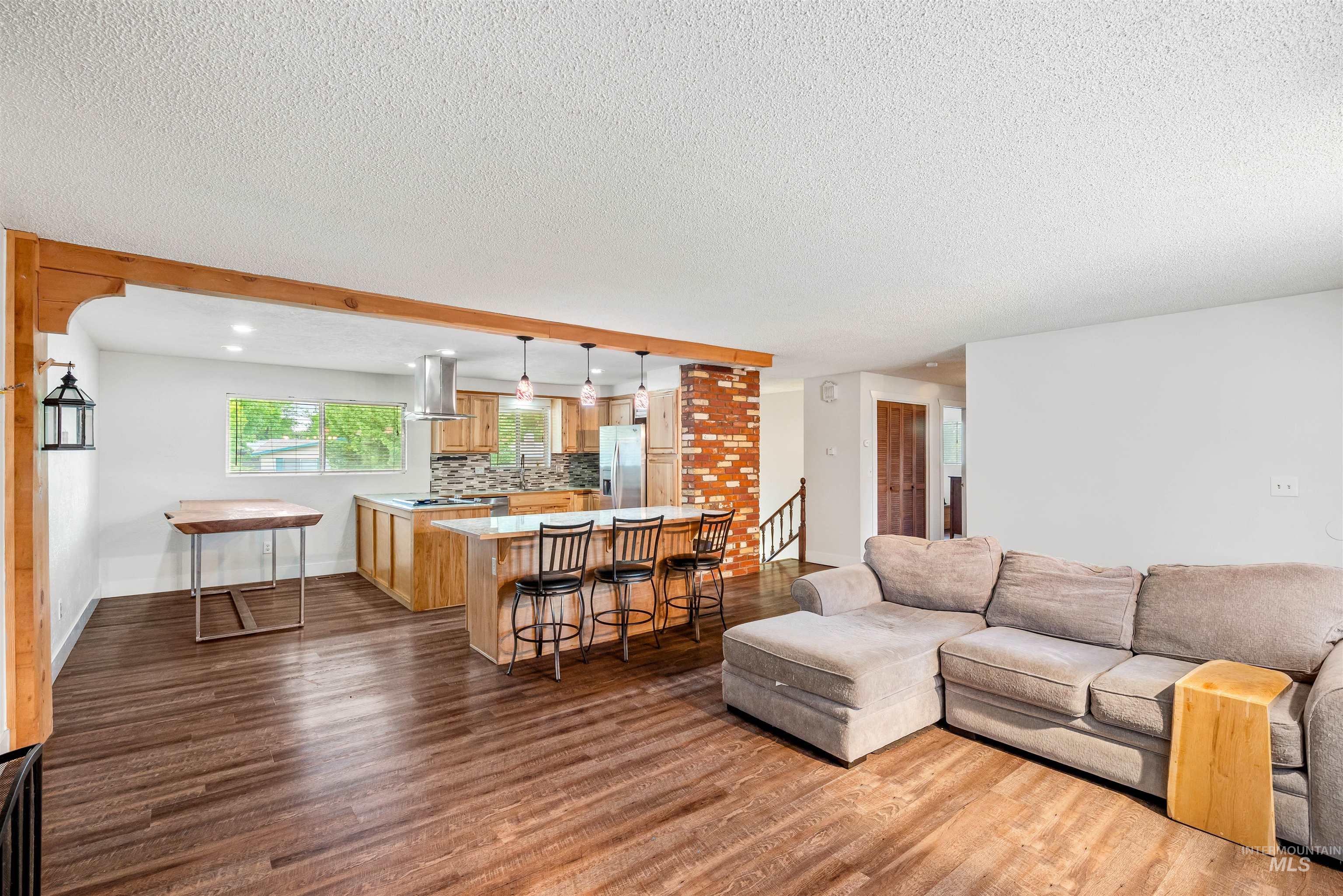 Living area featuring dark wood finished floors, a textured ceiling, and recessed lighting
