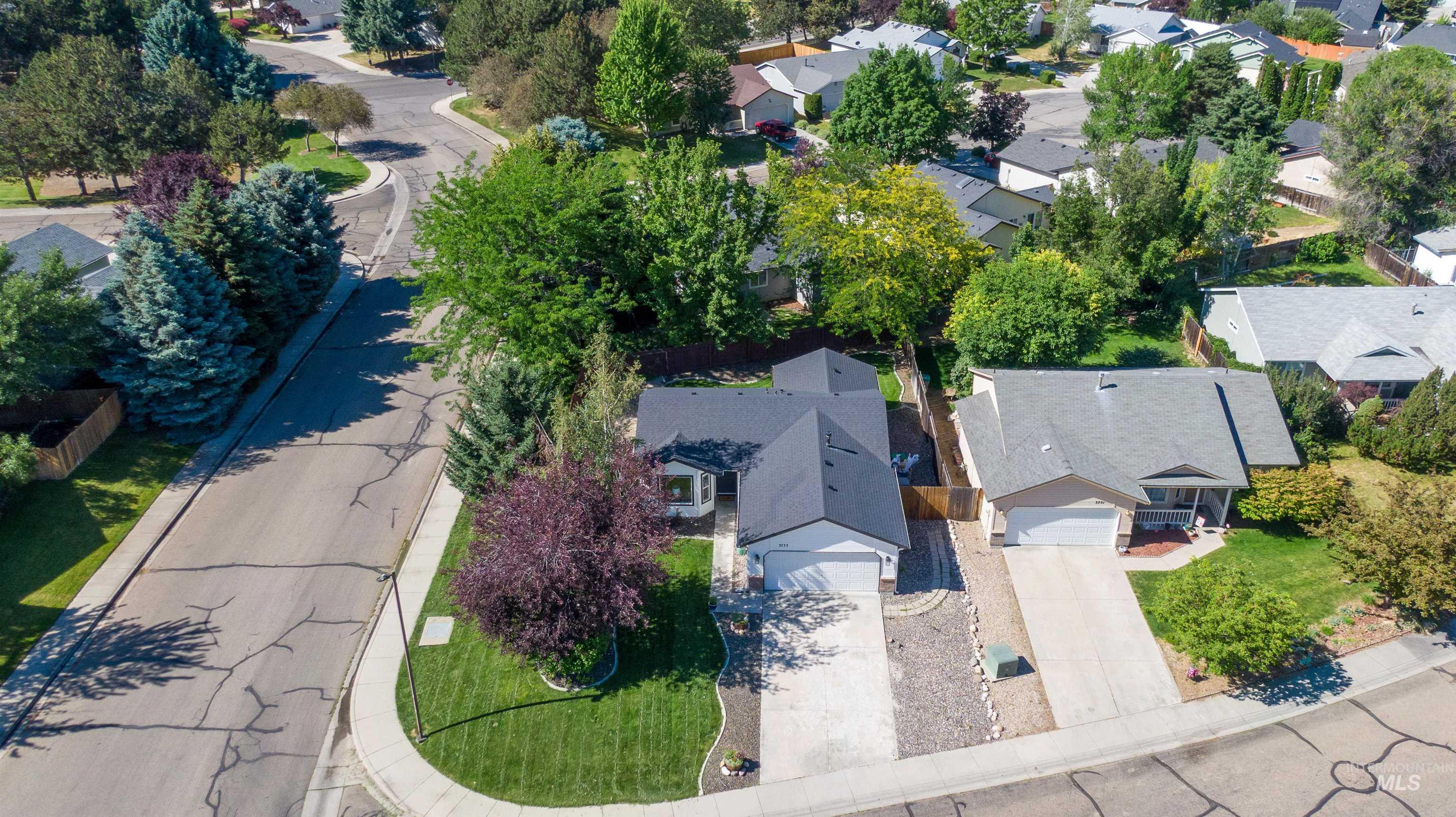 Single-story residential property featuring a dark gray shingle roof, attached two-car garage, and a manicured front lawn