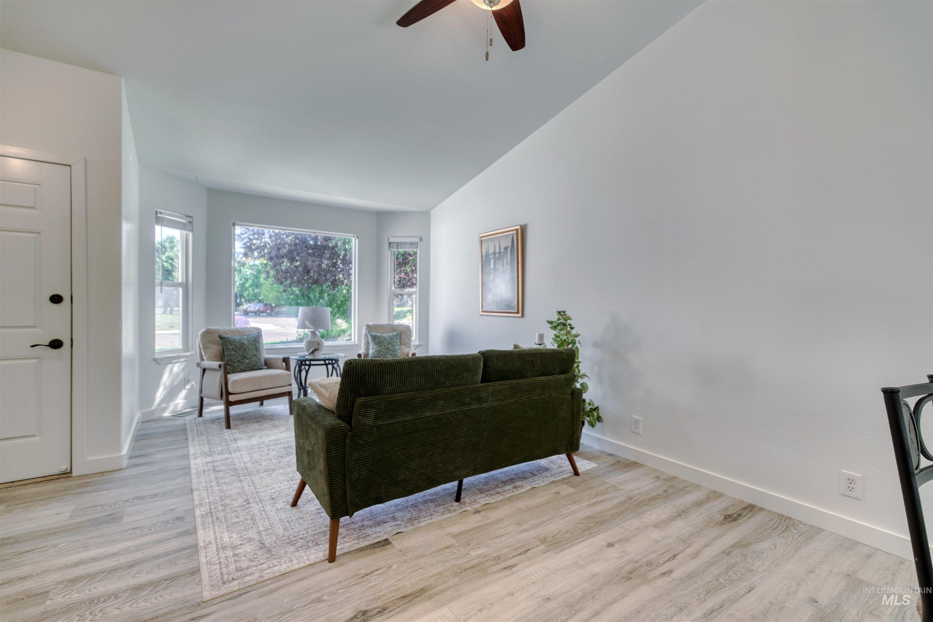 Bright living area featuring wood-finish flooring and a ceiling fan
