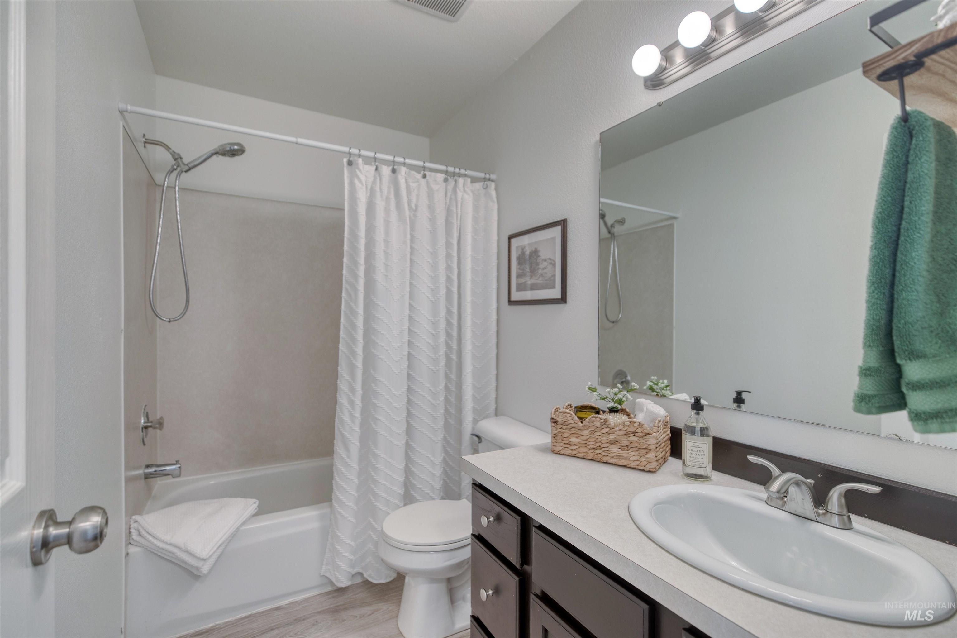 Full bathroom featuring a single vanity with dark wood-finish cabinetry, a built-in oval sink, and a brushed nickel faucet