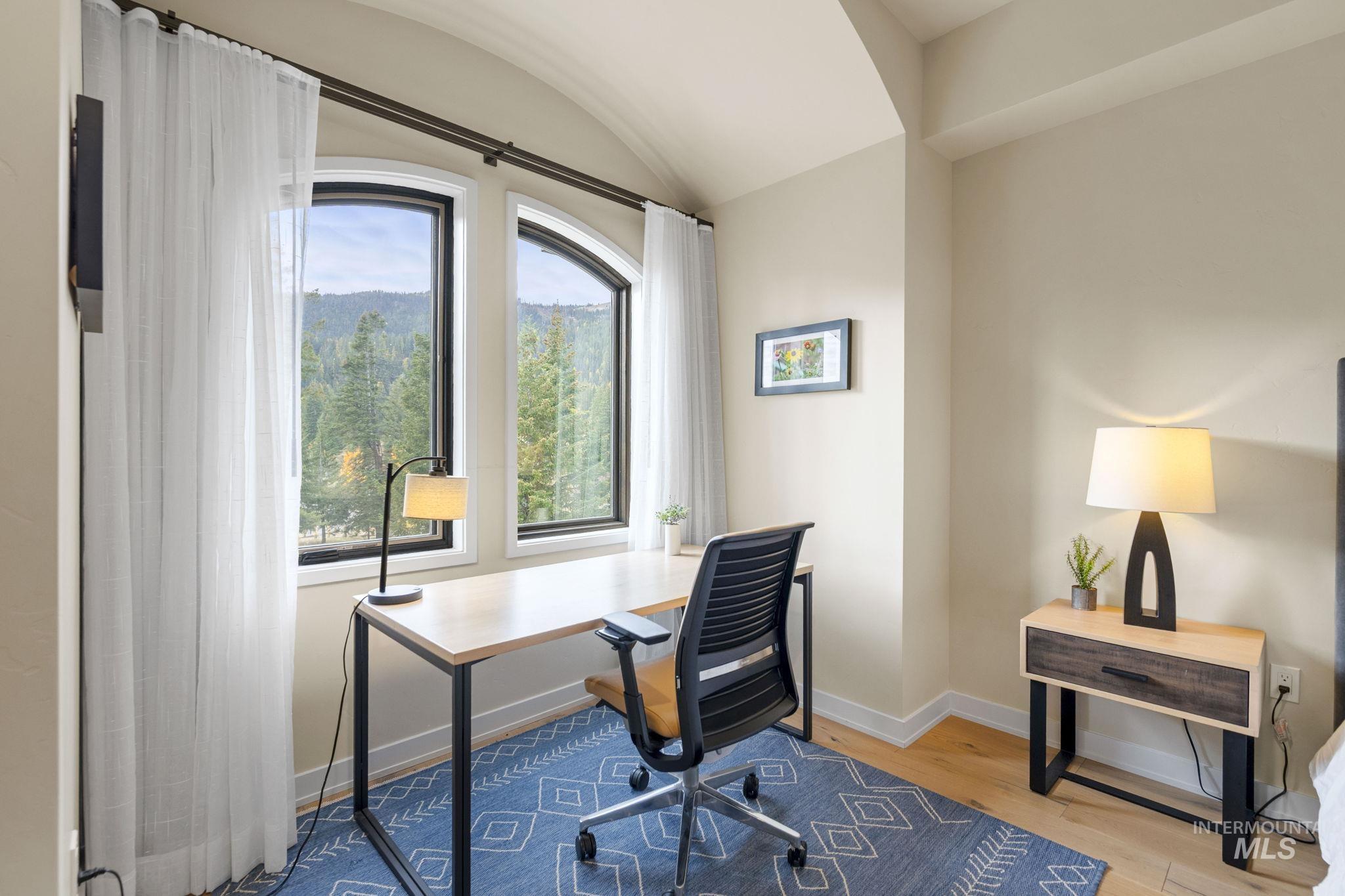 Office area featuring light wood-style flooring and lofted ceiling