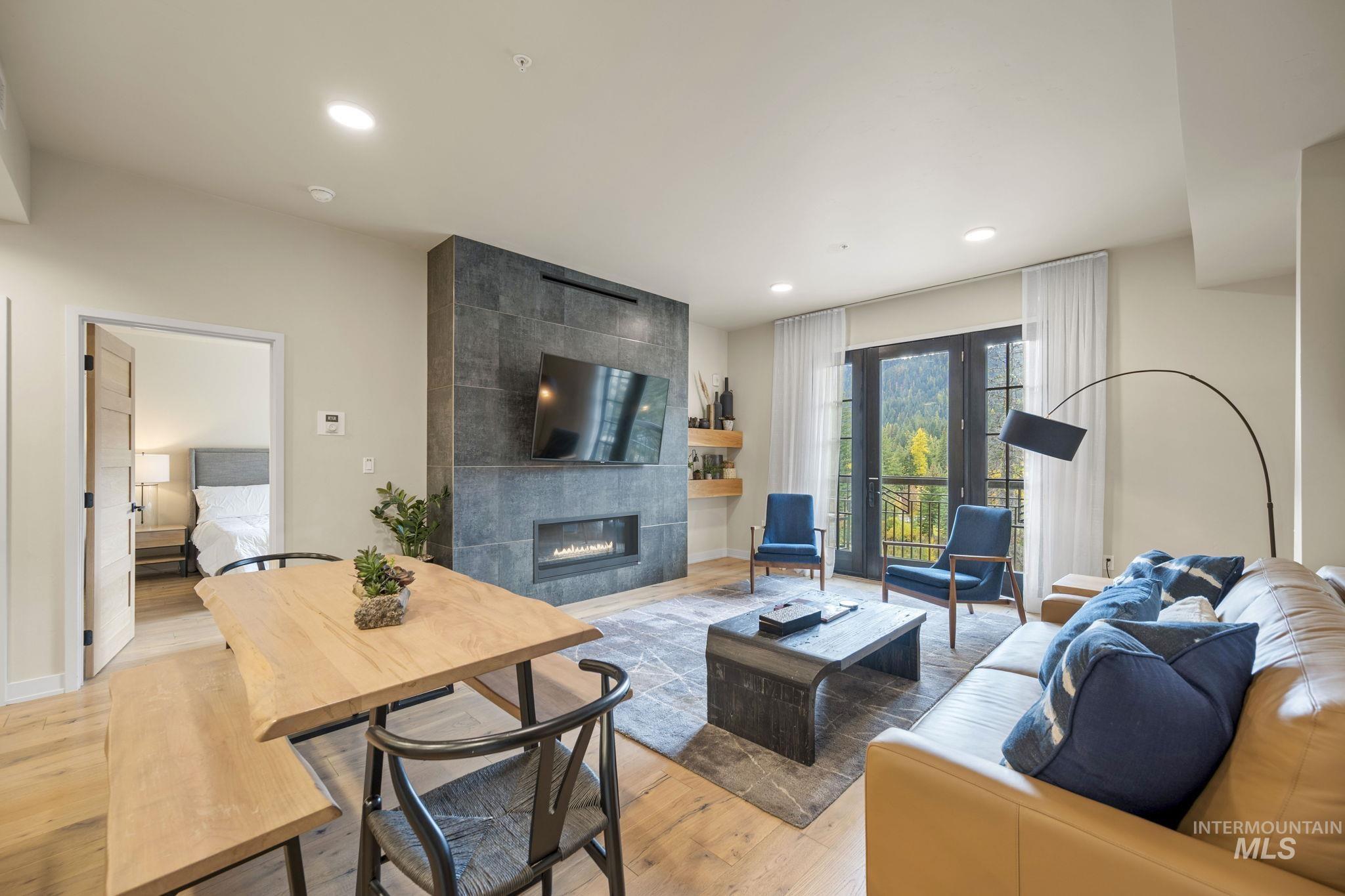 Living room with a tile fireplace, light wood-style floors, and recessed lighting
