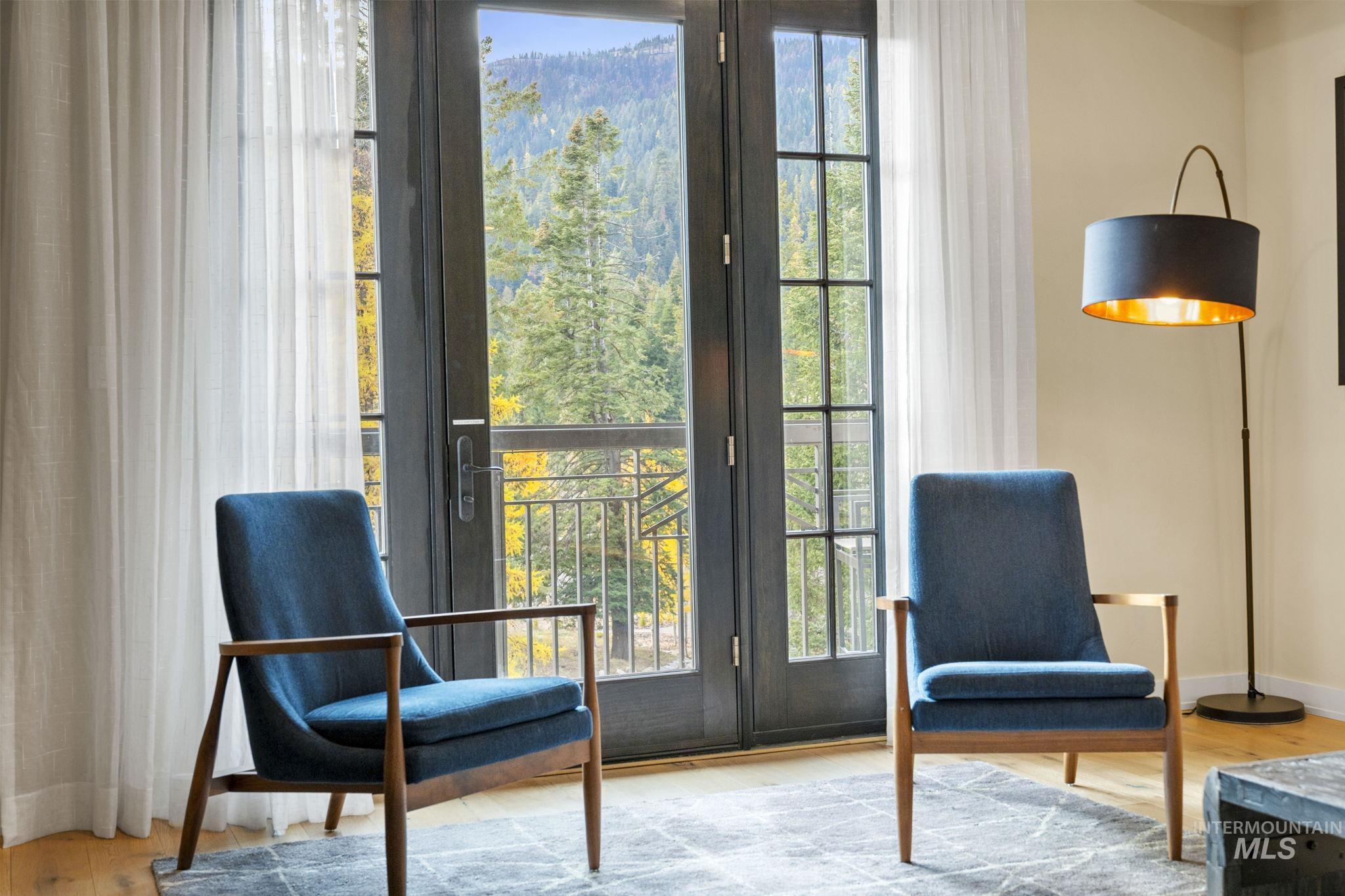 Sitting room with light wood-style floors and plenty of natural light