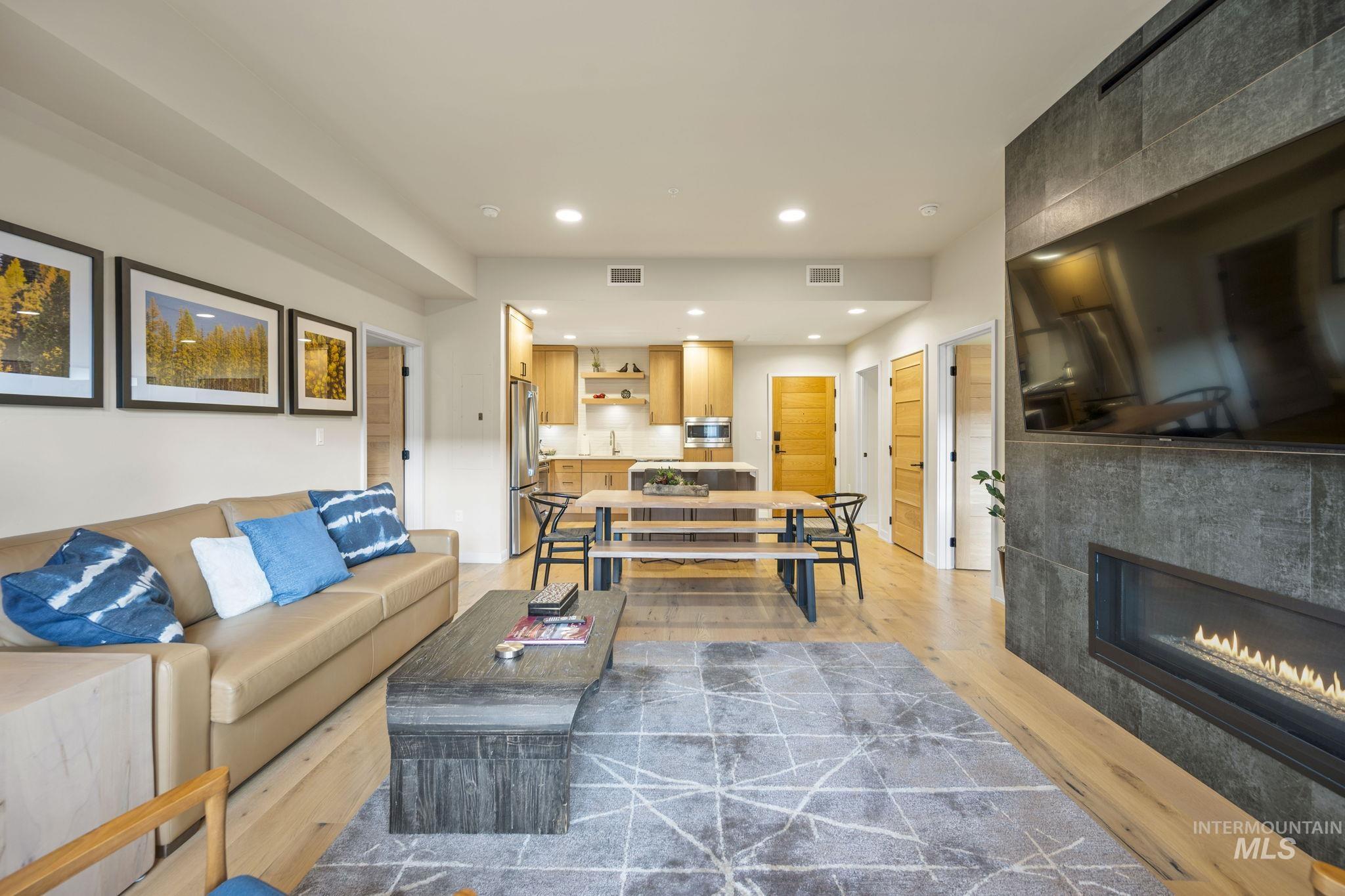 Living area featuring recessed lighting, a tile fireplace, and light wood-type flooring