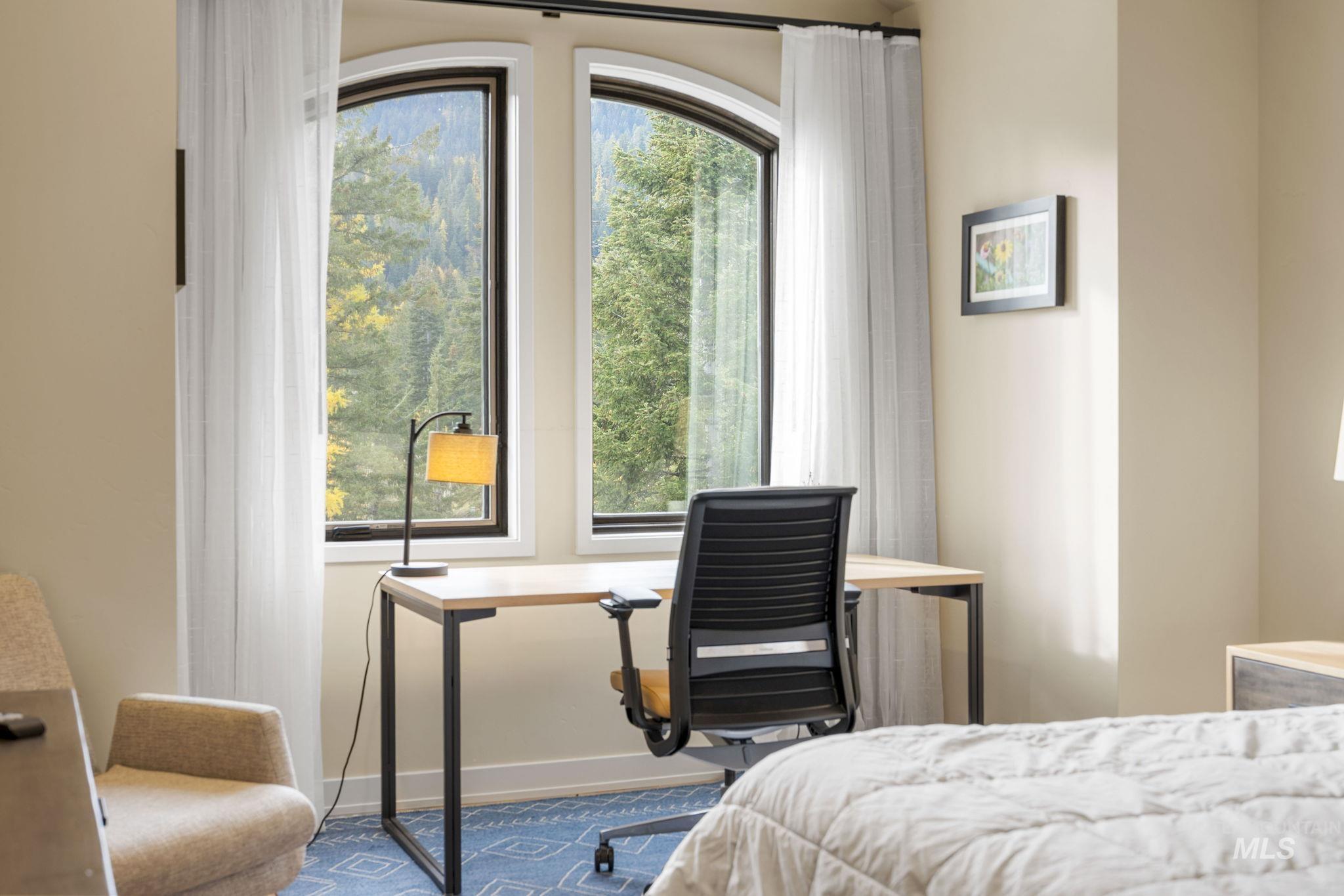 Bedroom featuring a desk and baseboards