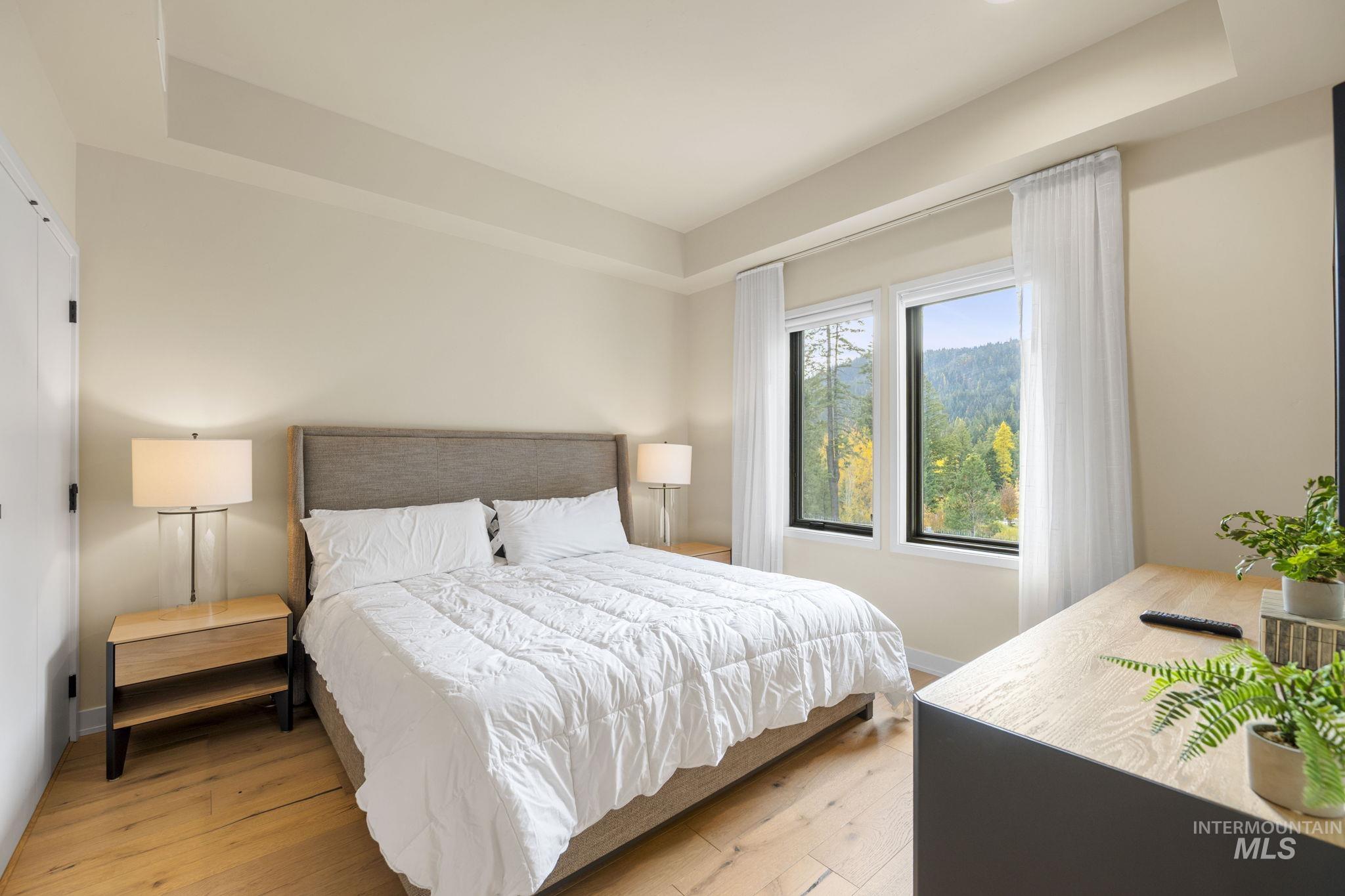 Bedroom with wood finished floors and a raised ceiling