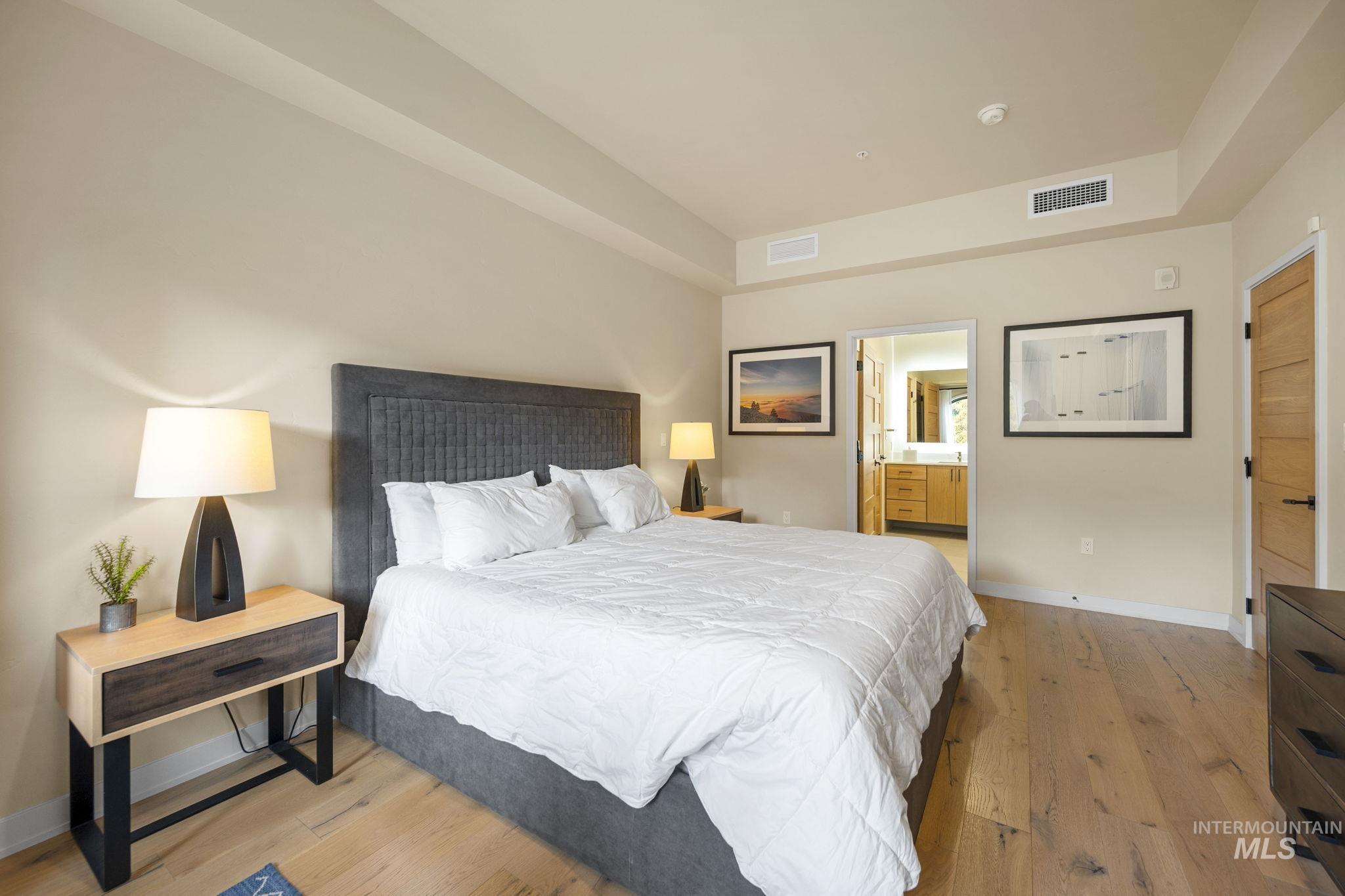 Bedroom featuring light wood-type flooring and ensuite bathroom