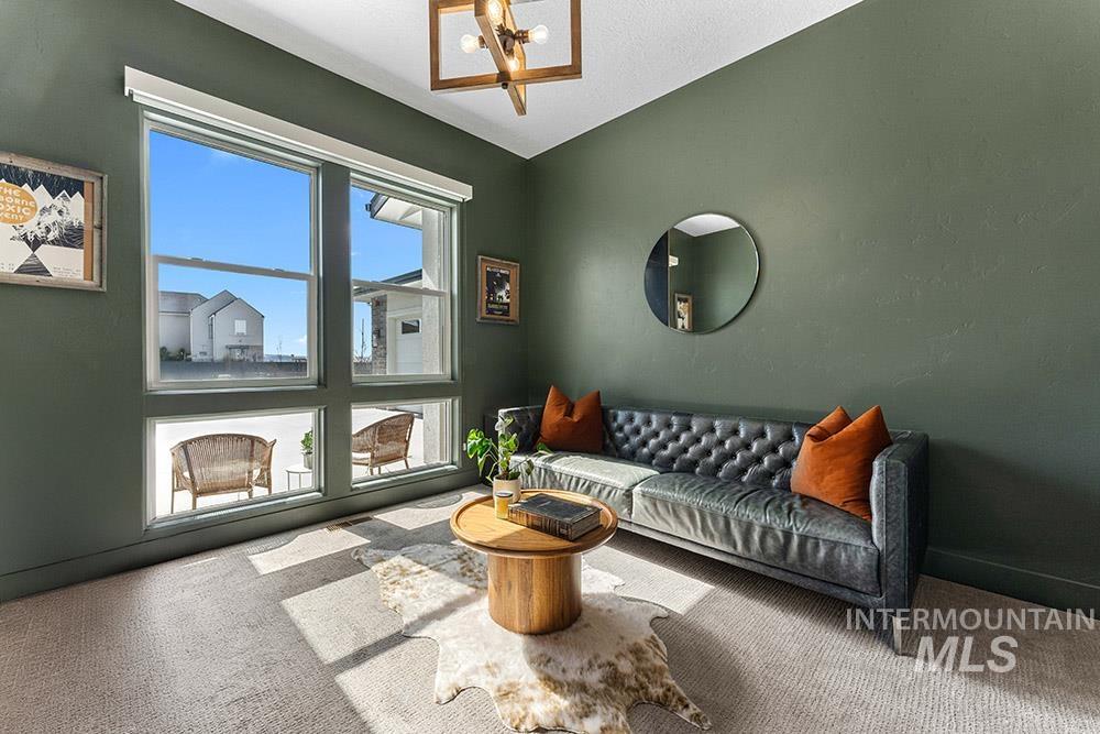 Carpeted living room featuring a chandelier and lofted ceiling