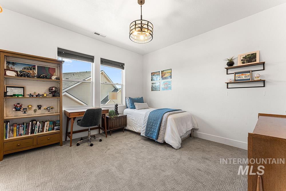 Bedroom with light colored carpet and baseboards