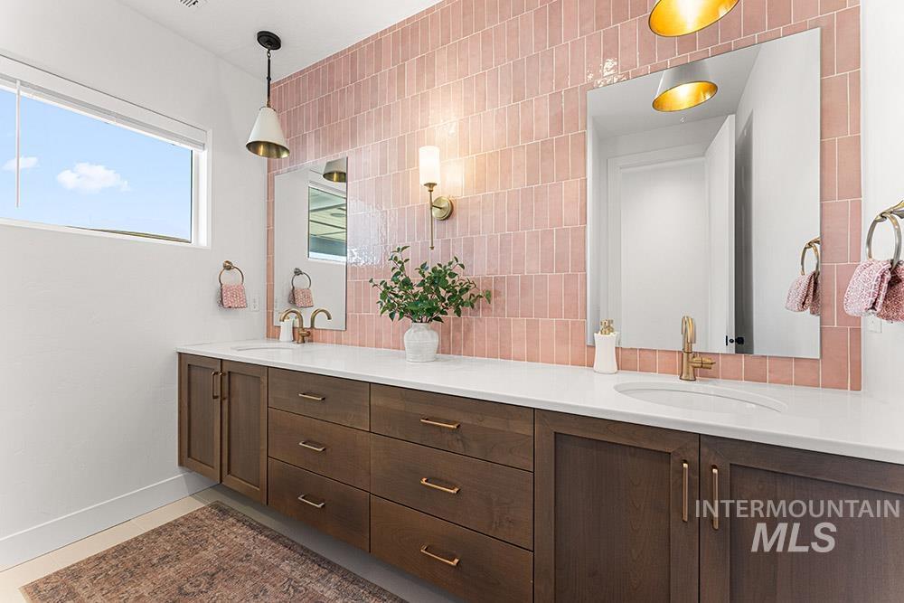 Full bathroom featuring double vanity and decorative backsplash