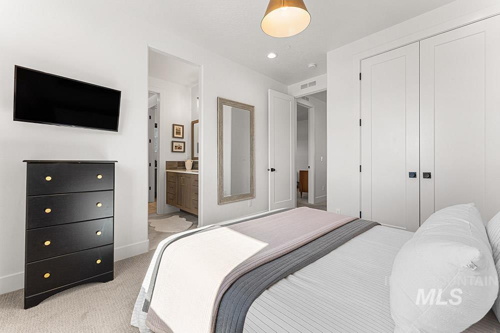 Bedroom with light carpet, a closet, and ensuite bathroom