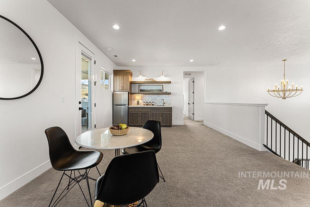 Dining area with light carpet, a chandelier, and recessed lighting
