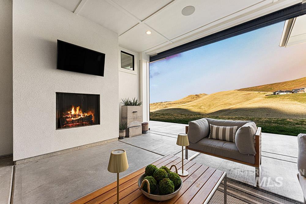 View of patio with a lit fireplace