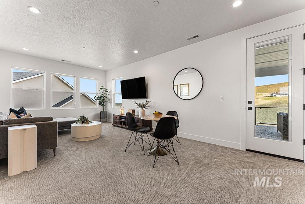 Dining area featuring light colored carpet, recessed lighting, and a textured ceiling