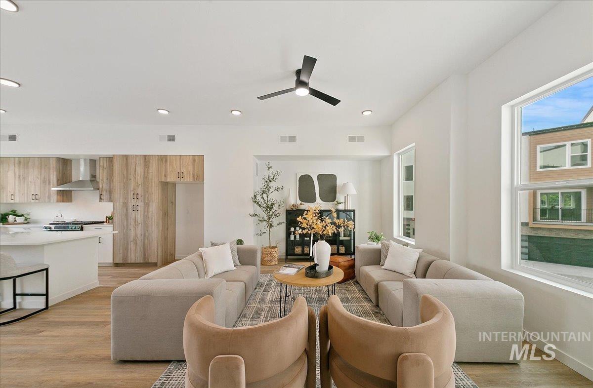 Living area featuring light wood finished floors, ceiling fan, and recessed lighting
