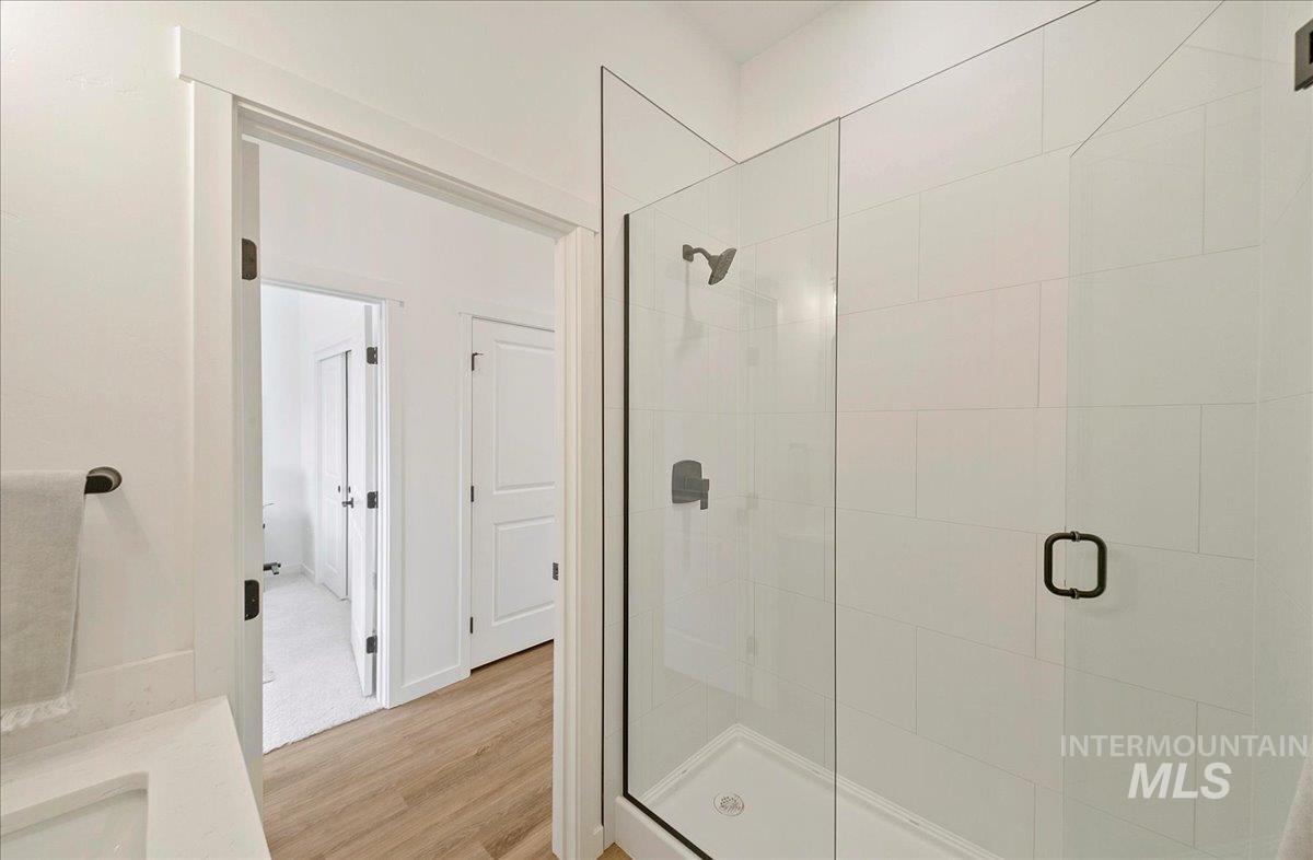 Bathroom featuring a stall shower, light wood finished floors, and vanity