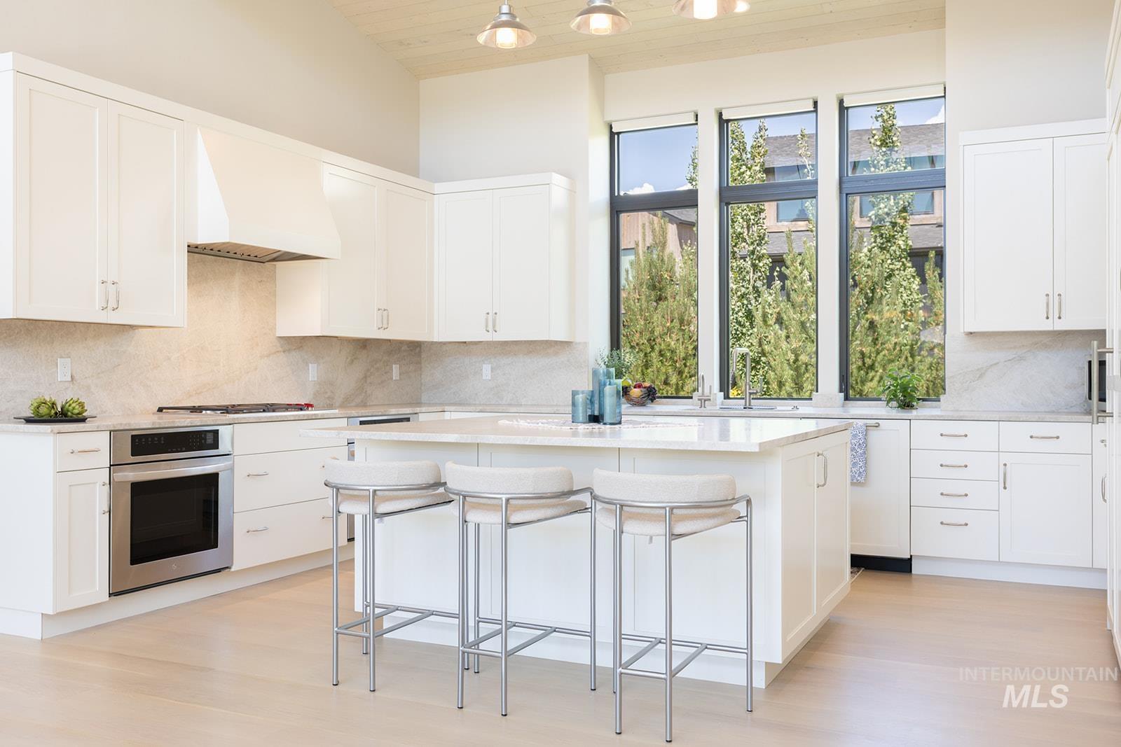 Kitchen with wood ceiling, a center island, oven, custom exhaust hood, and a kitchen bar