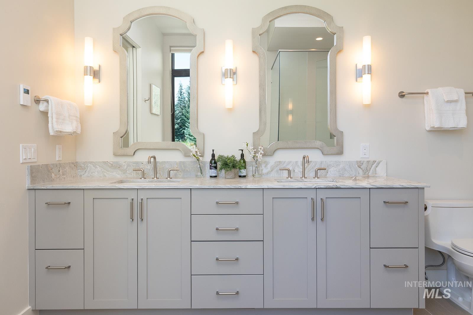 Full bath with double vanity and a shower with door