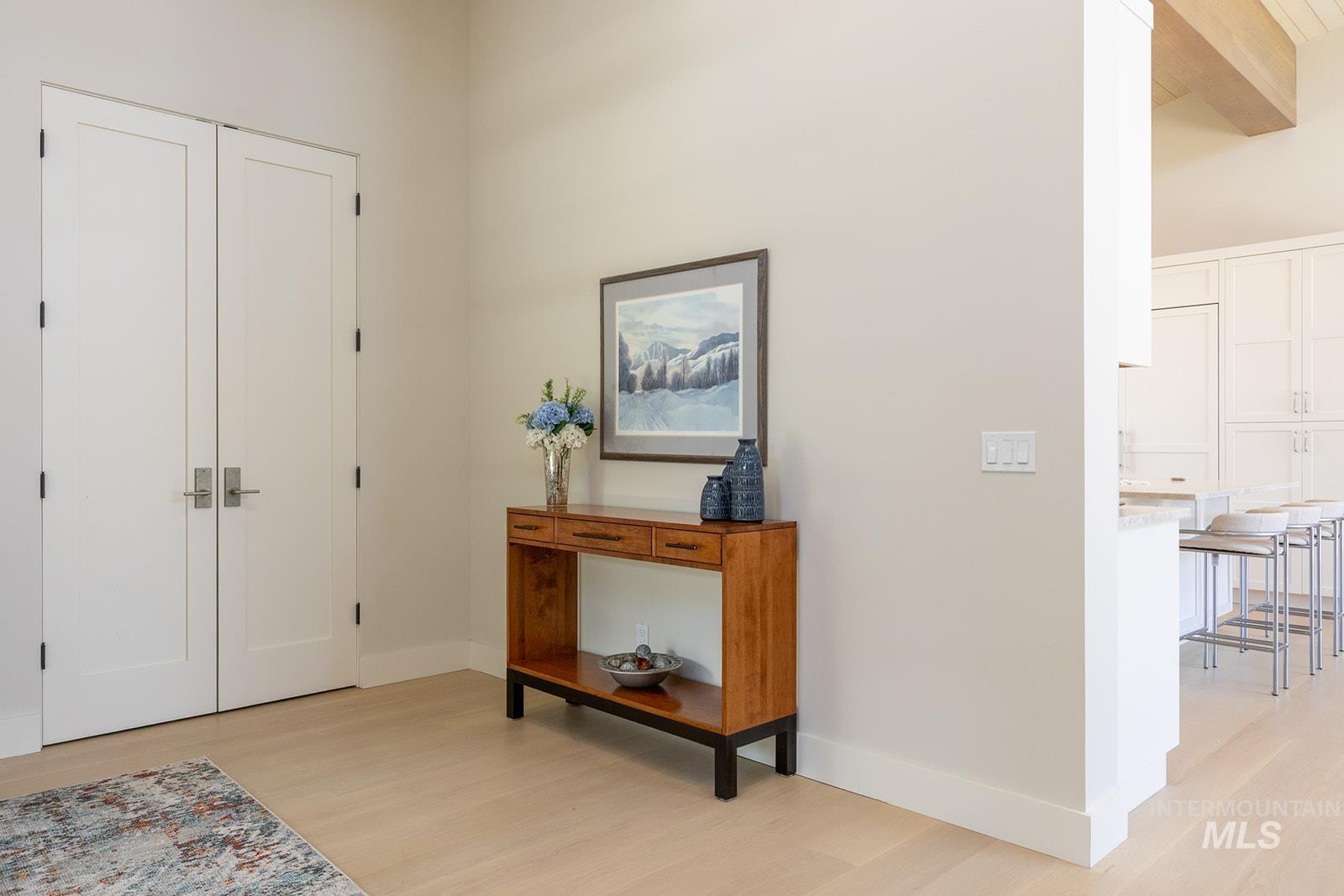 Entryway featuring light wood-style floors and beam ceiling