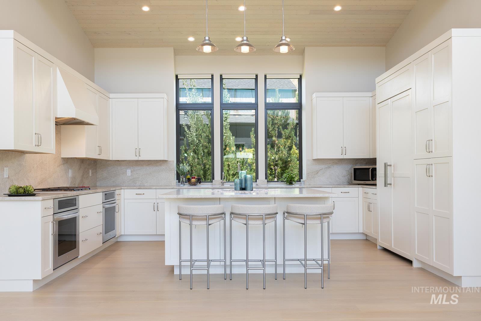 Kitchen featuring wood ceiling, a center island, a breakfast bar area, light countertops, and recessed lighting