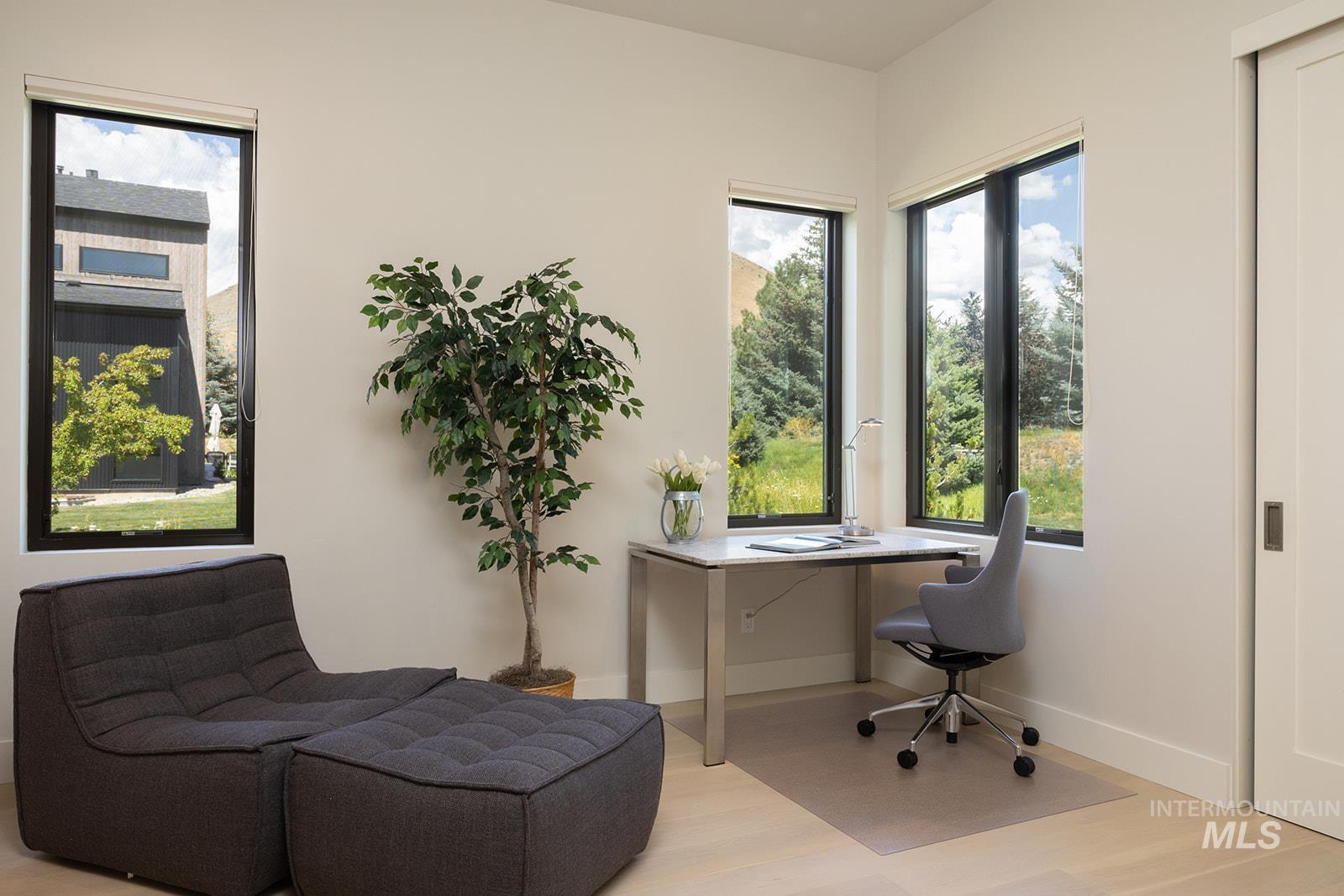 Office area with light wood-style floors and healthy amount of natural light