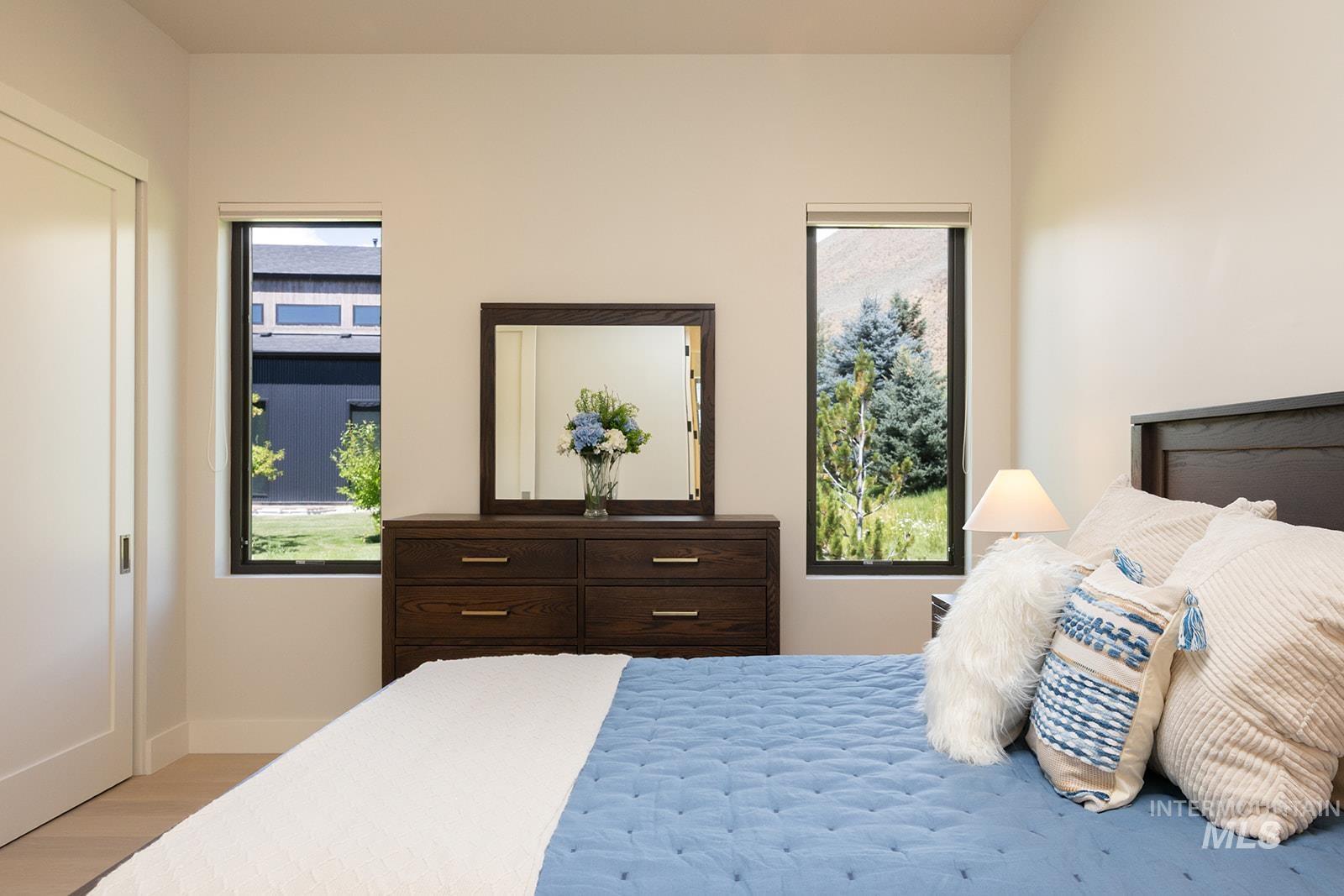 Bedroom with multiple windows and wood finished floors